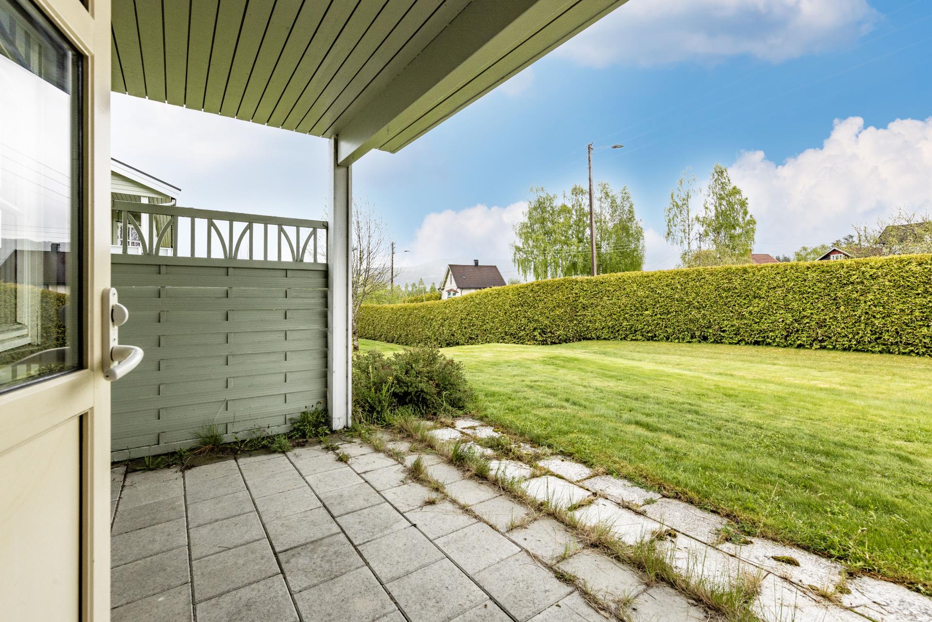 Fra stuen er det utgang til en overbygget markterrasse. Her er det plass til en sittegruppe, med direkte tilgang til fellesarealene.. Bilde nummer 3 av 3