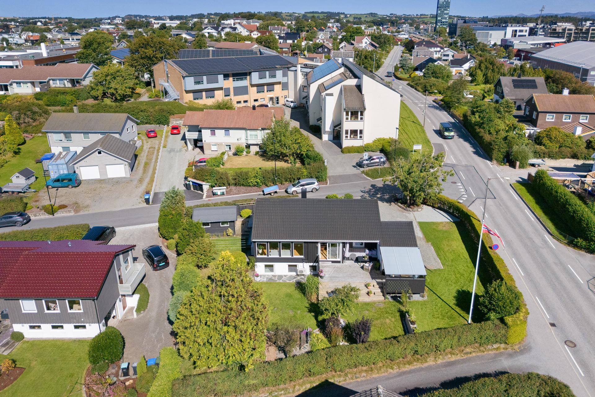 Boligen ligger fint plassert på tomten med stor hage og skjermede uteområder.. Bilde nummer 3 av 3