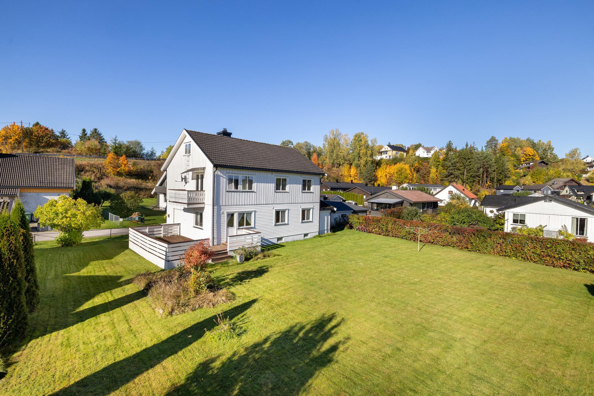 Stor og flat gresstomt med hekk og gode bruksmuligheter for lek og opphold.. Bilde nummer 3 av 3