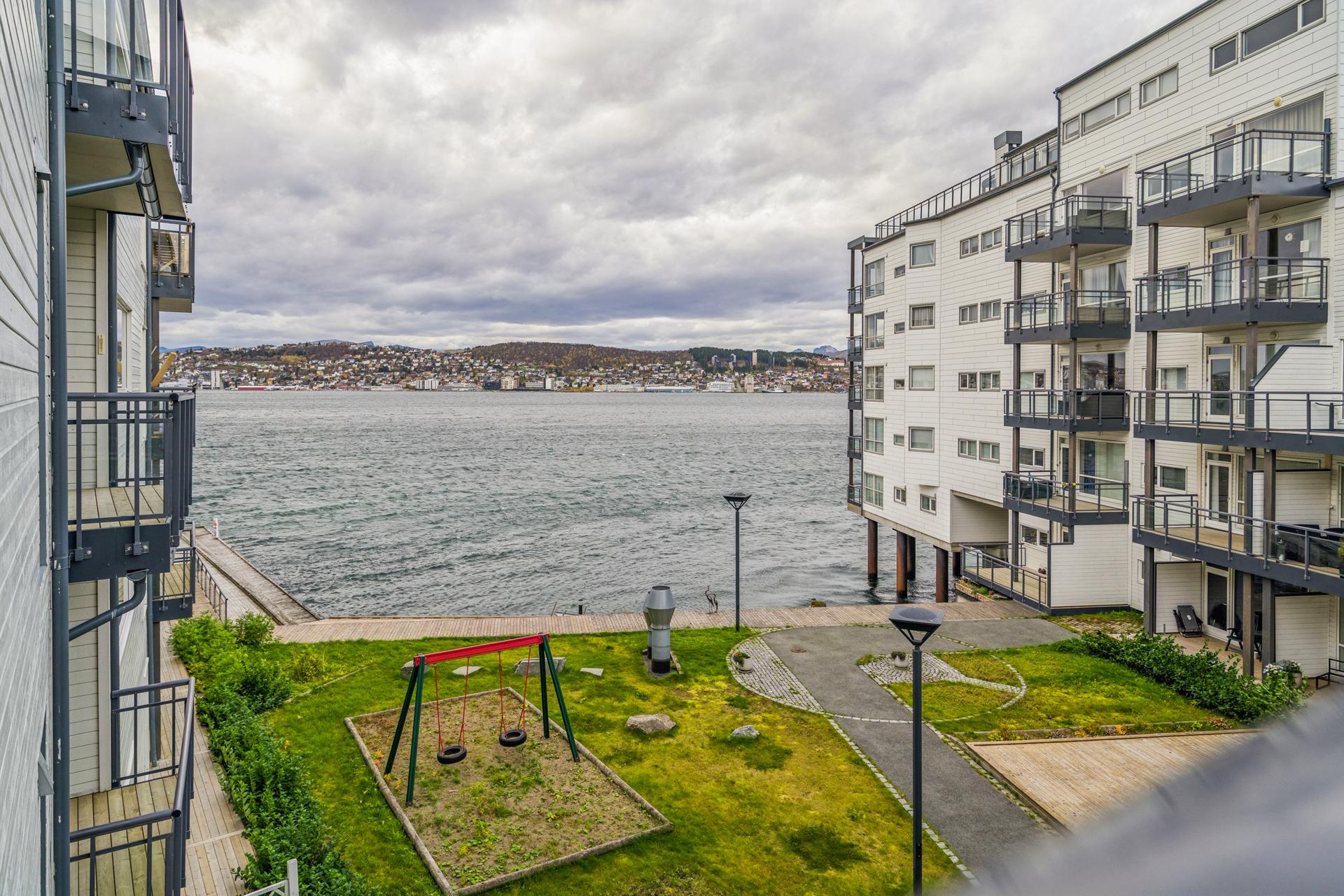 Beliggenheten i vannkanten gir utsyn over Tromsøysundet og grønne fellesarealer.. Bilde nummer 2 av 3