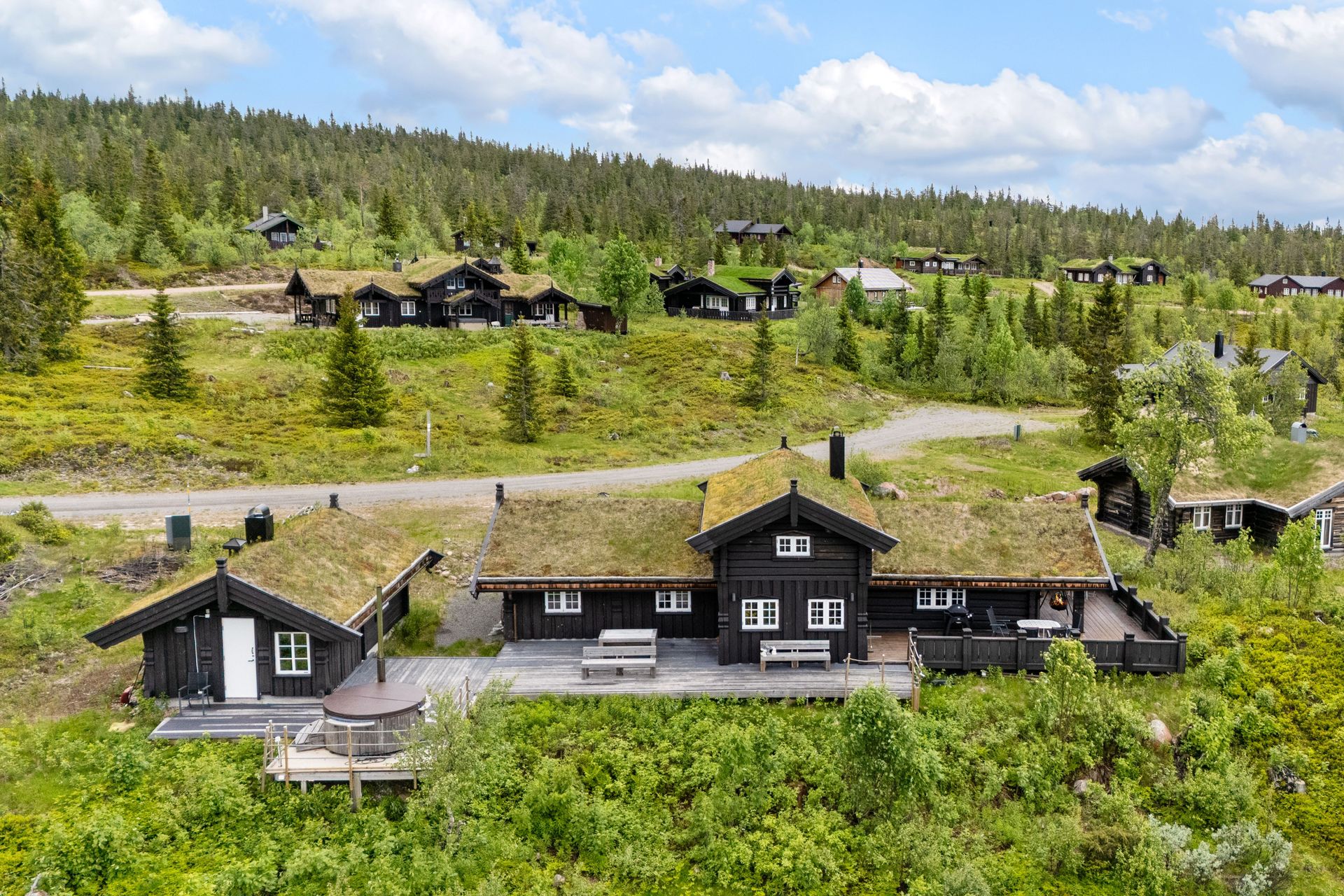 Eiendommen består av en laftet fritidsbolig og et frittstående anneks, begge med tradisjonelt torvtak.. Bilde nummer 2 av 3