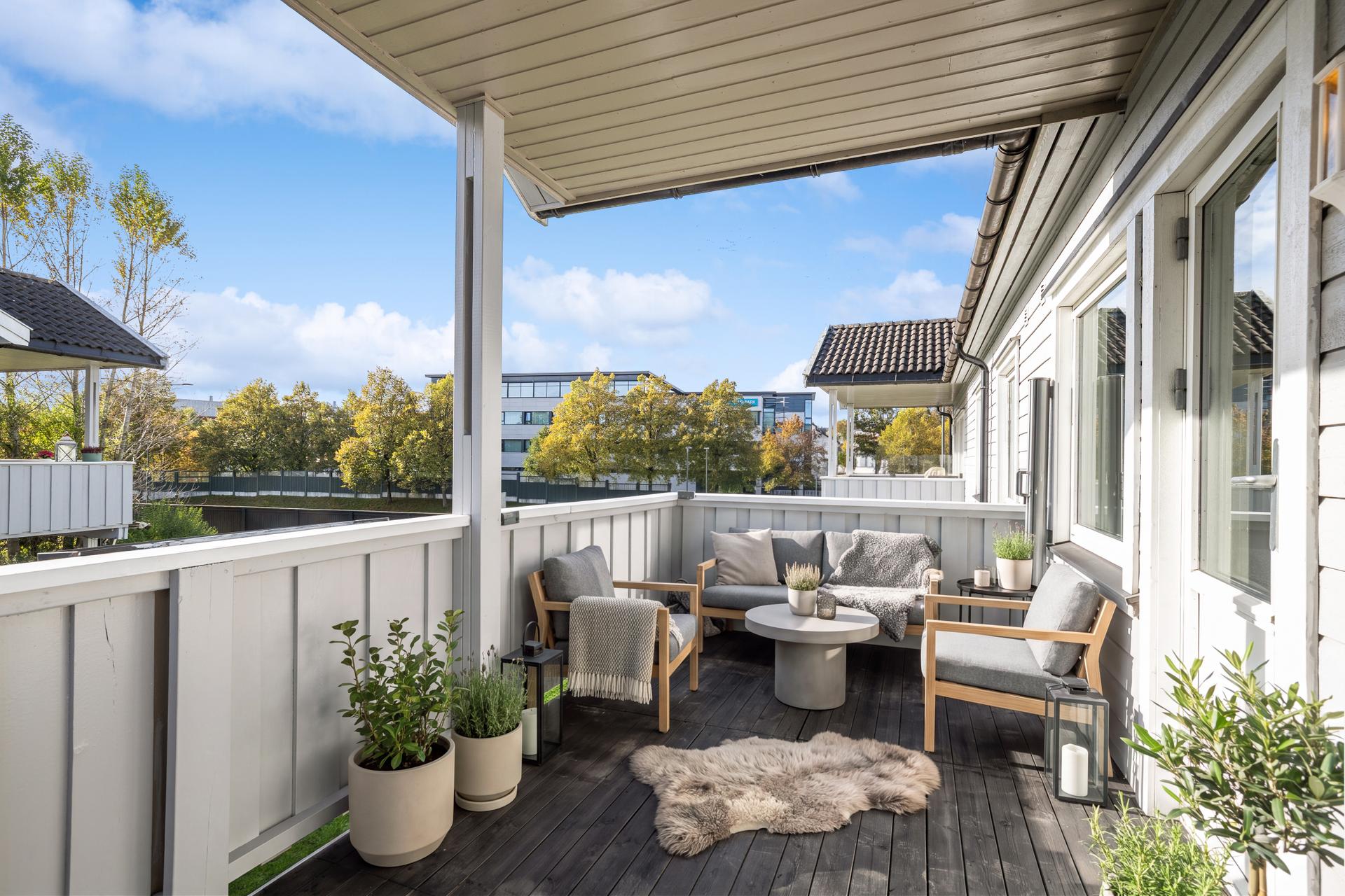 Fra stuen er det direkte utgang til den overbygde verandaen på ca. 10 m². Dette gir en fin forlengelse av oppholdsrommet på varme dager og gjør det enkelt å trekke ut i frisk luft med morgenkaffen eller ettermiddagsmåltidet.. Bilde nummer 3 av 3