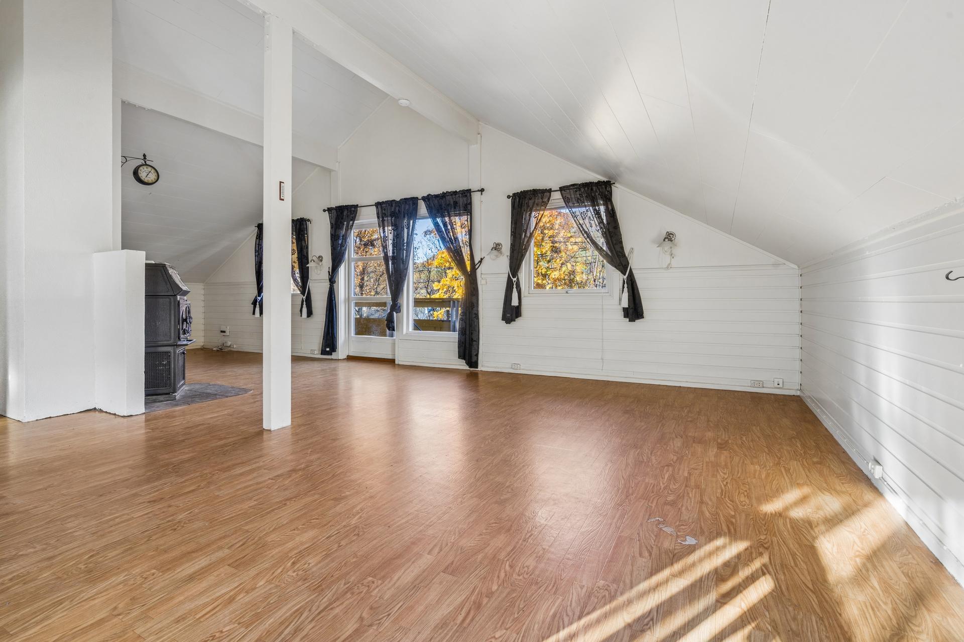 I andre etasje har boligen en lys og luftig stue med vedovn og utgang til veranda.. Bilde nummer 3 av 3