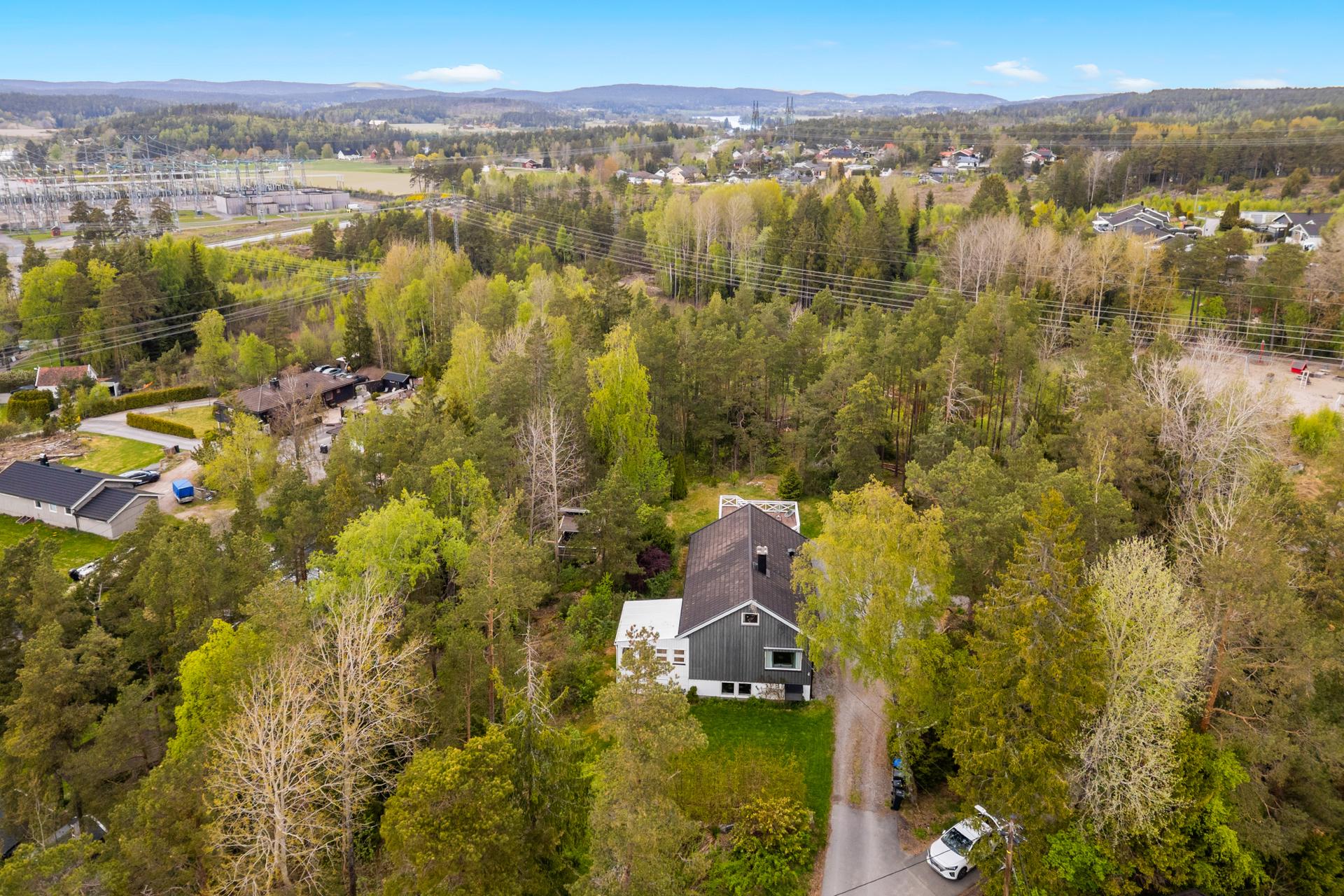Enebolig over tre plan med en stor, usjenert tomt. Eiendommen er omkranset av natur og har en gruset gårdsplass med integrert garasje.. Bilde nummer 3 av 3