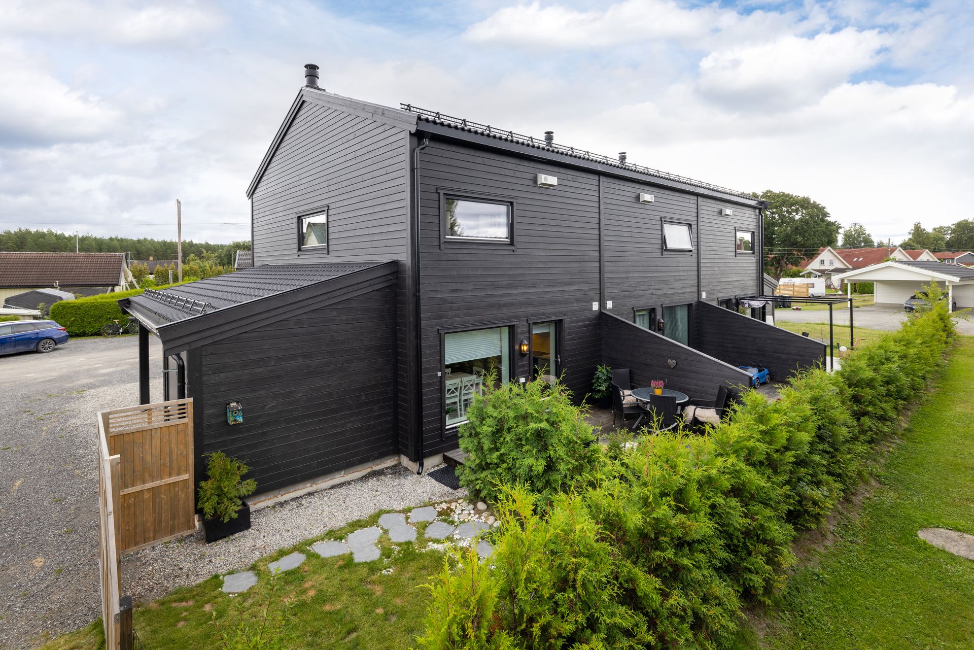 Fasade med liggende bordkledning og tak tekket med betongtakstein. Foto: Normann Foto AS v/Morten Normann Larsen. Bilde nummer 1 av 3