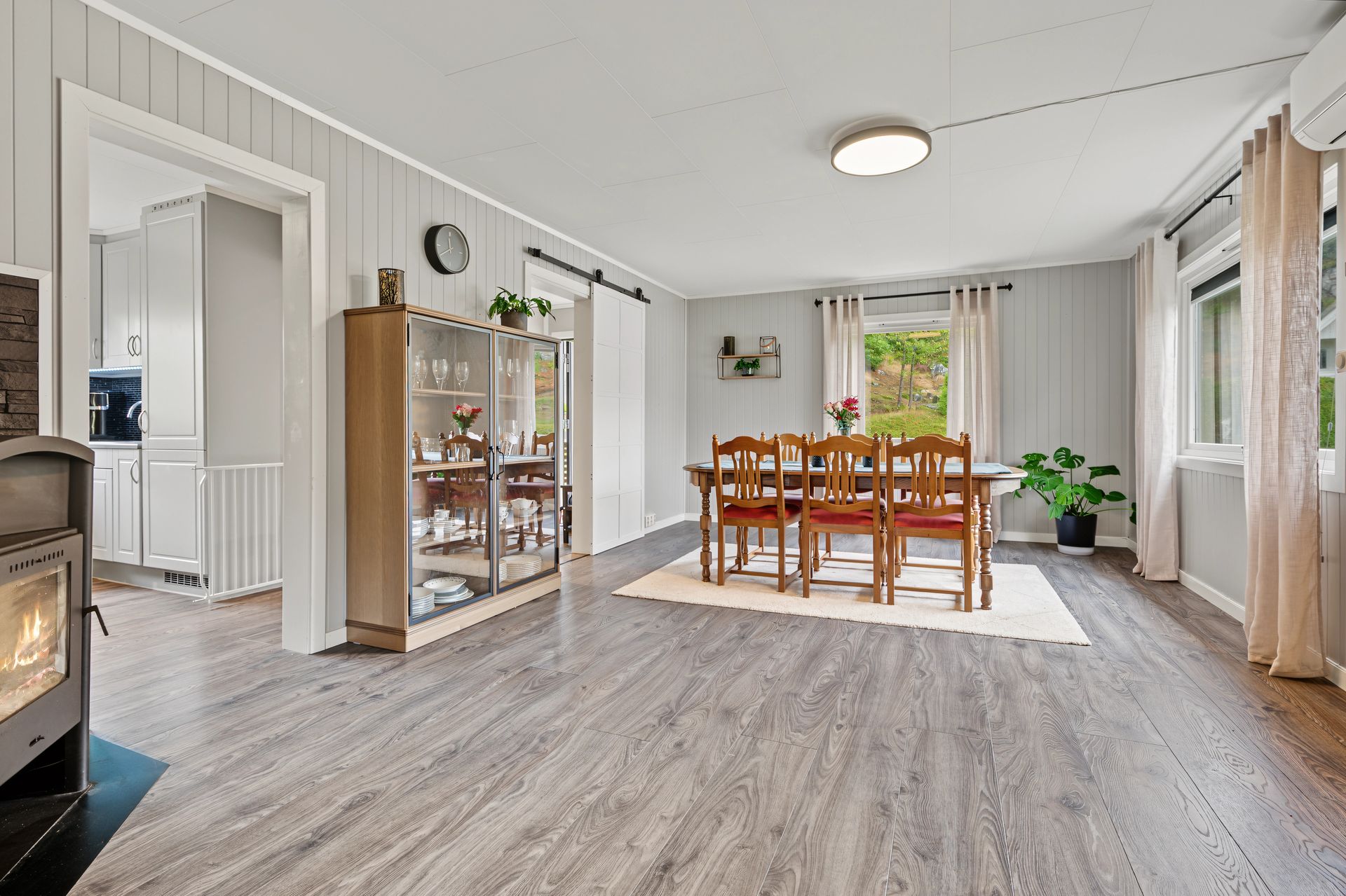 Romslig stue med vedovn og god plass til både spisebord og sittegruppe.. Bilde nummer 3 av 3