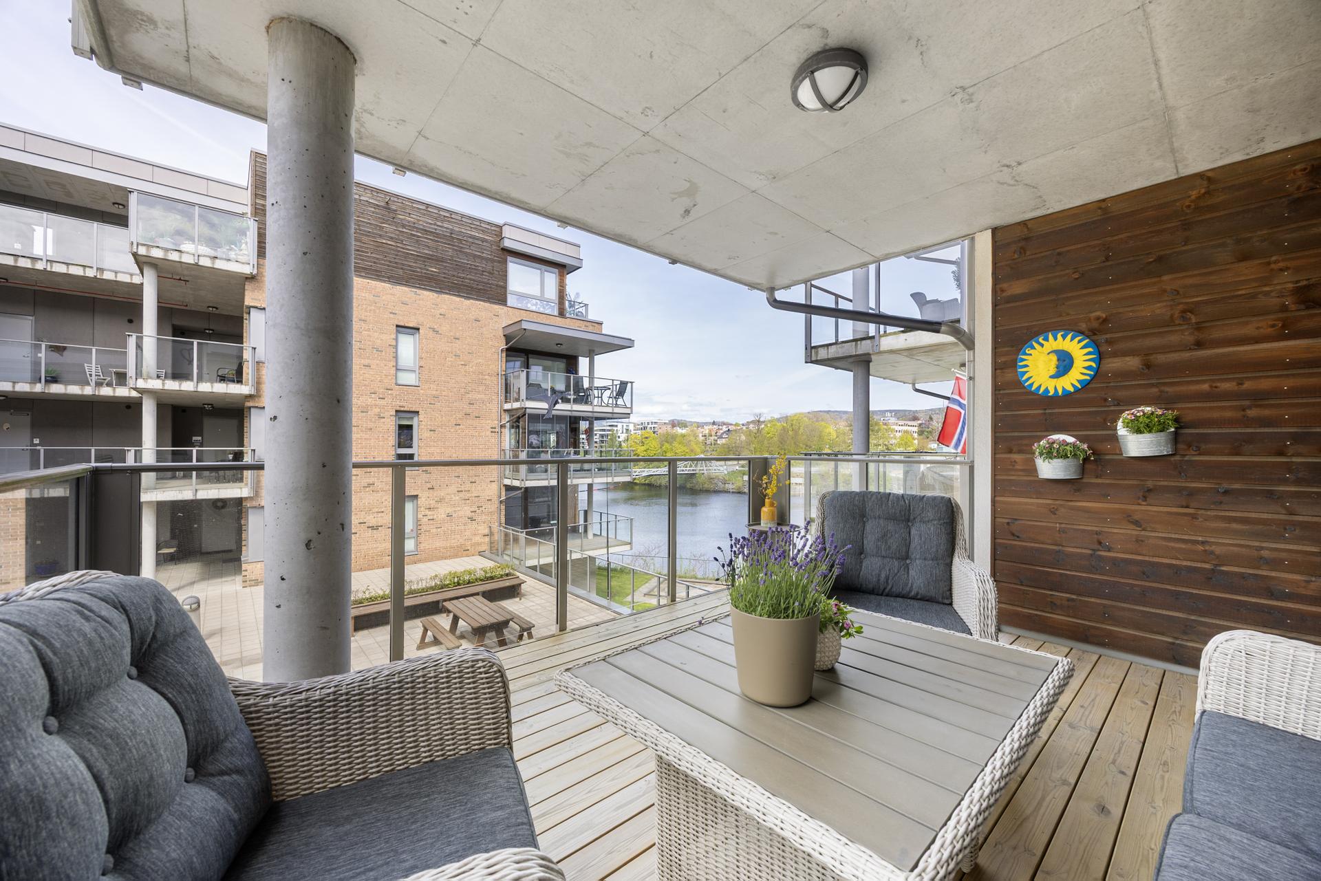 Boligen har en flott og overbygget veranda på 13 m² med god plass til sittegruppe og fin utsikt mot fellesarealene og vannet.. Bilde nummer 3 av 3