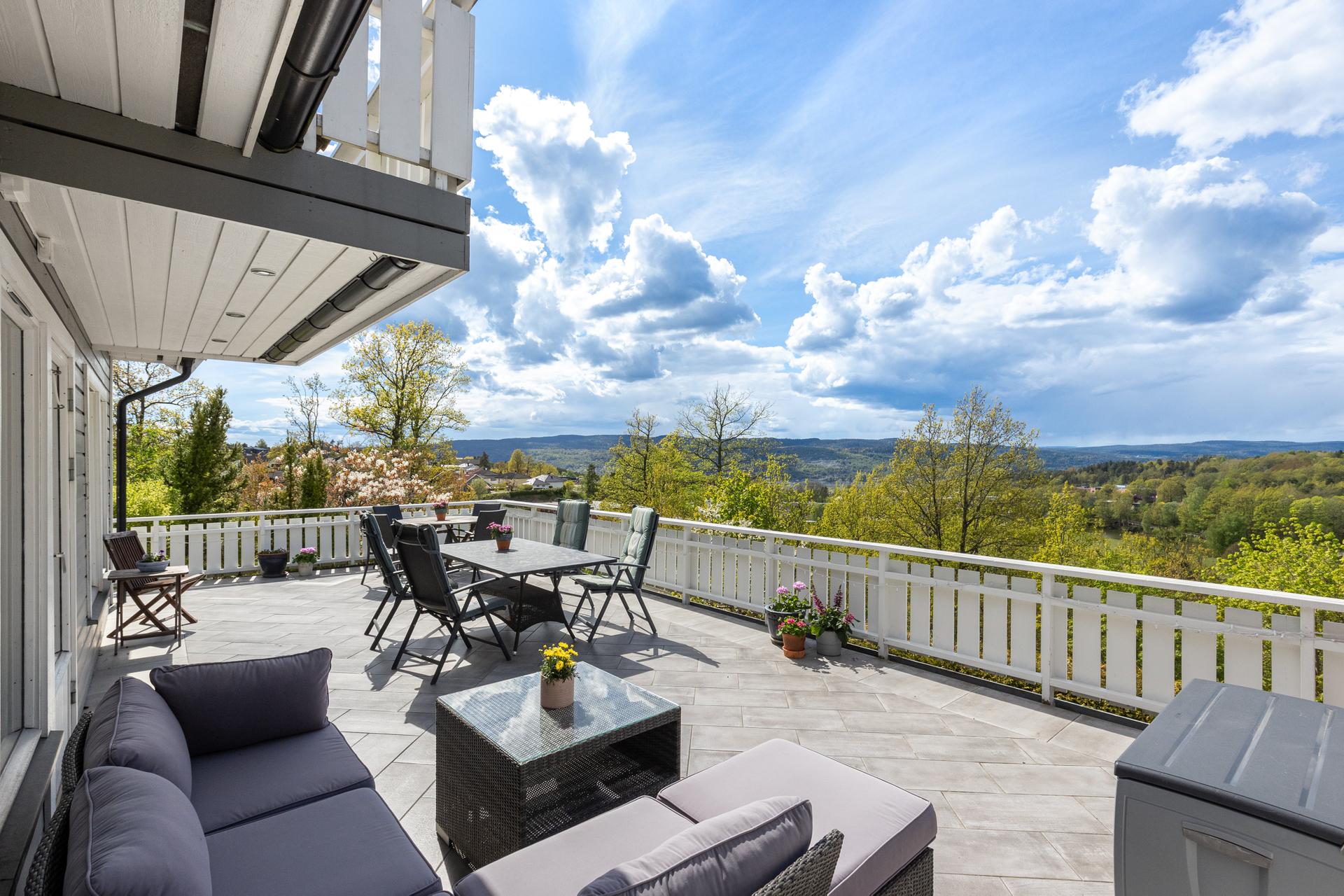 Stor og solrik flislagt terrasse utenfor stuen i 1. etasje. . Bilde nummer 2 av 3