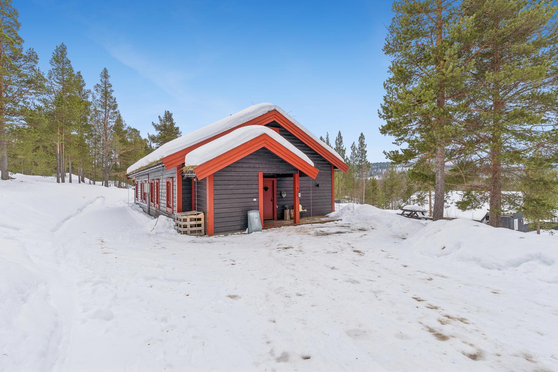 Eiendommen ligger fint til i terrenget med gruset adkomst og parkering.. Bilde nummer 3 av 3