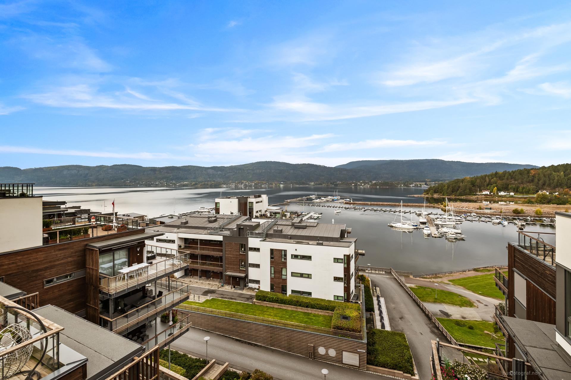 Utsyn over bryggeområdet med havnepromenade og grønne fellesarealer.. Bilde nummer 3 av 3