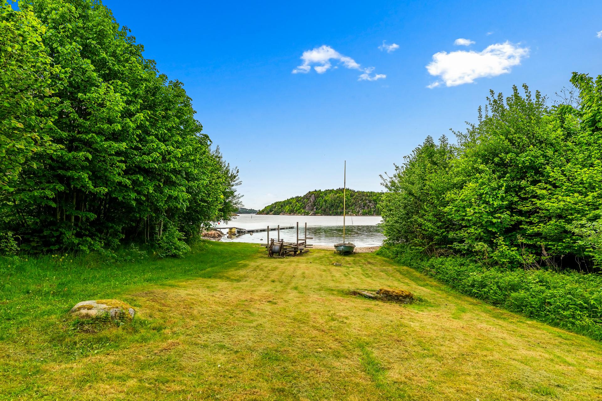 Rett nedenfor eiendommen følger det med en strandparsell. Bilde nummer 2 av 3