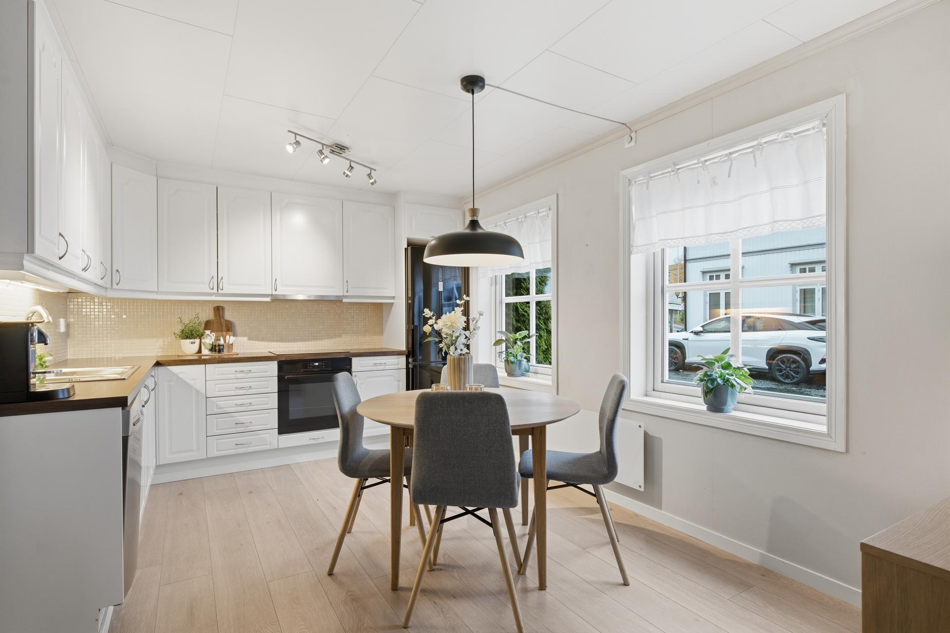 Kjøkkenet har åpen løsning mot stuen og plass til spisebord ved vinduet.. Bilde nummer 3 av 3