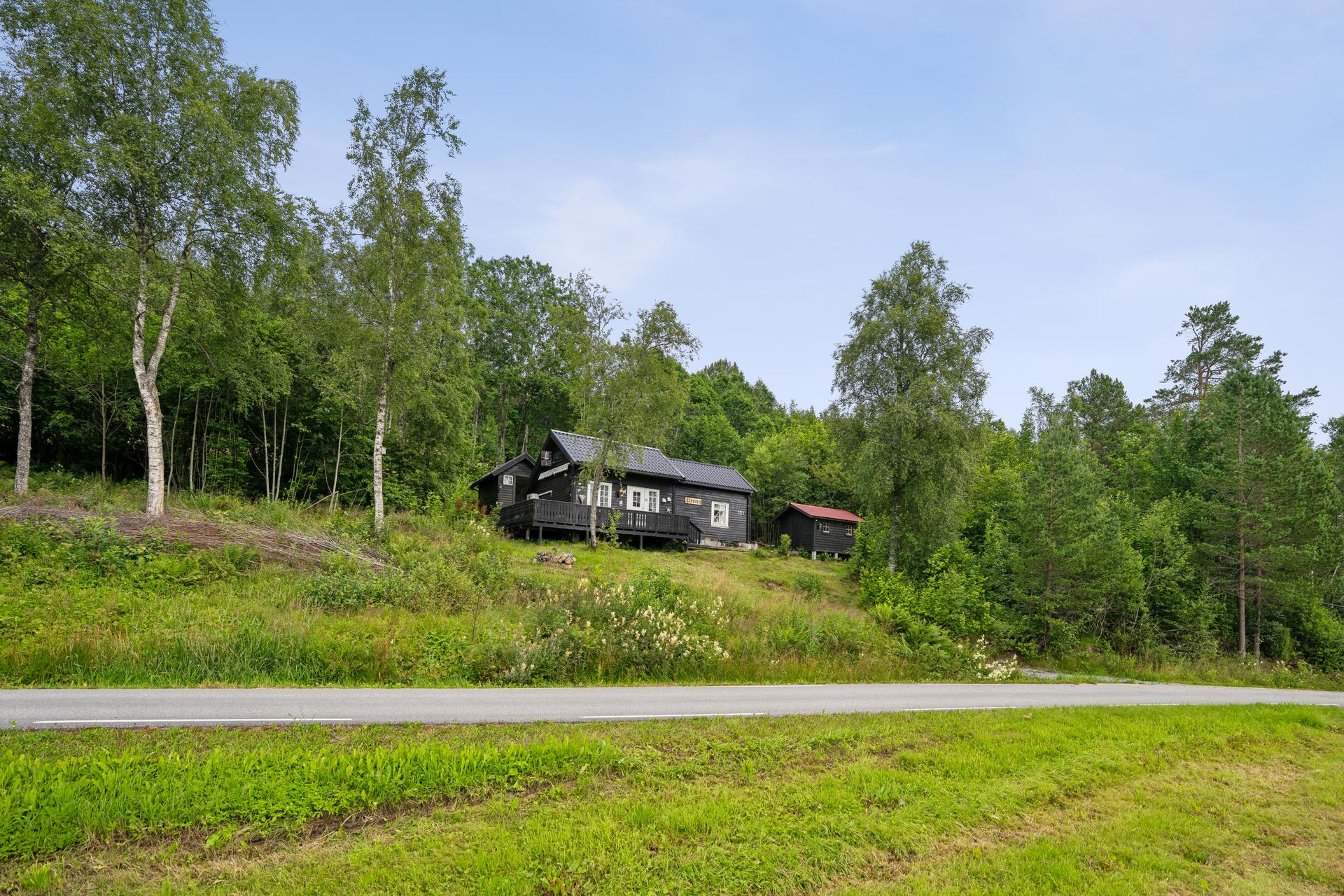 Hytta har en naturskjønn beliggenhet omgitt av skog og grøntarealer.. Bilde nummer 2 av 3
