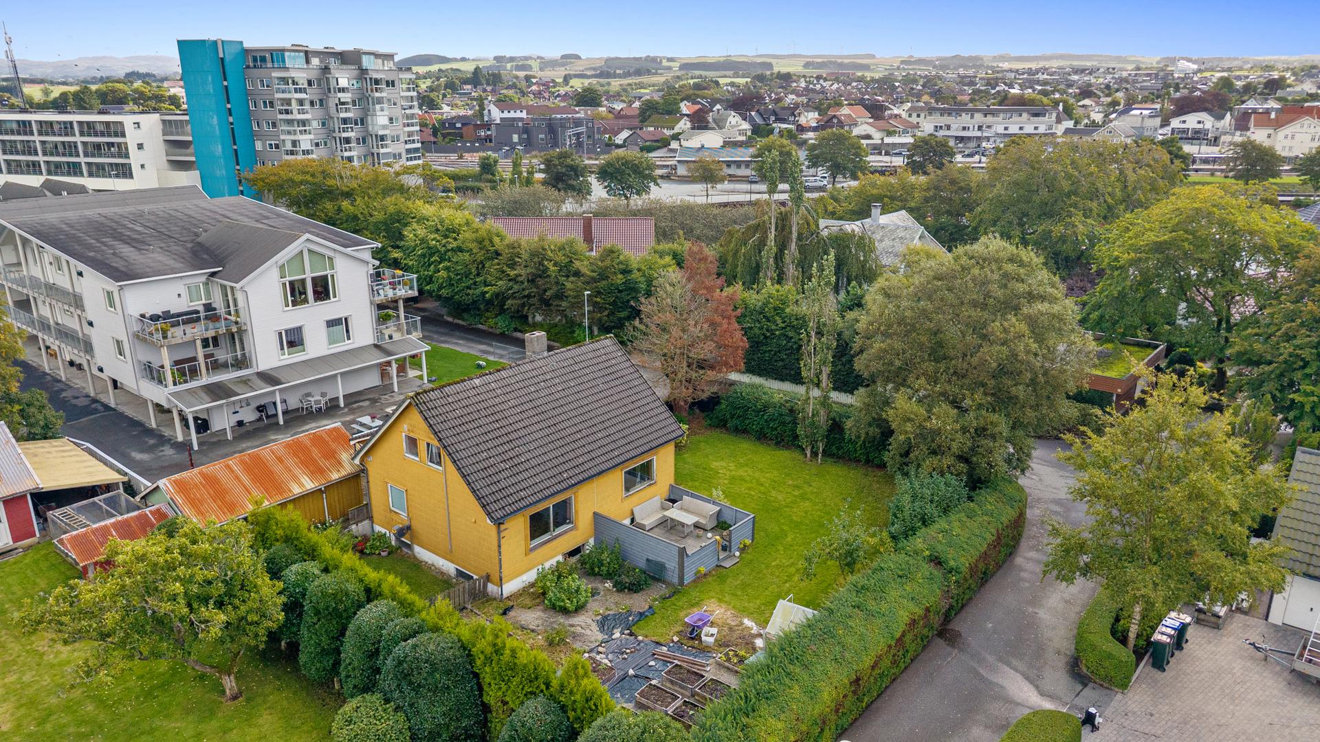 Stor hage som er opparbeidet med plen, plantekasser og drivhus. . Bilde nummer 2 av 3