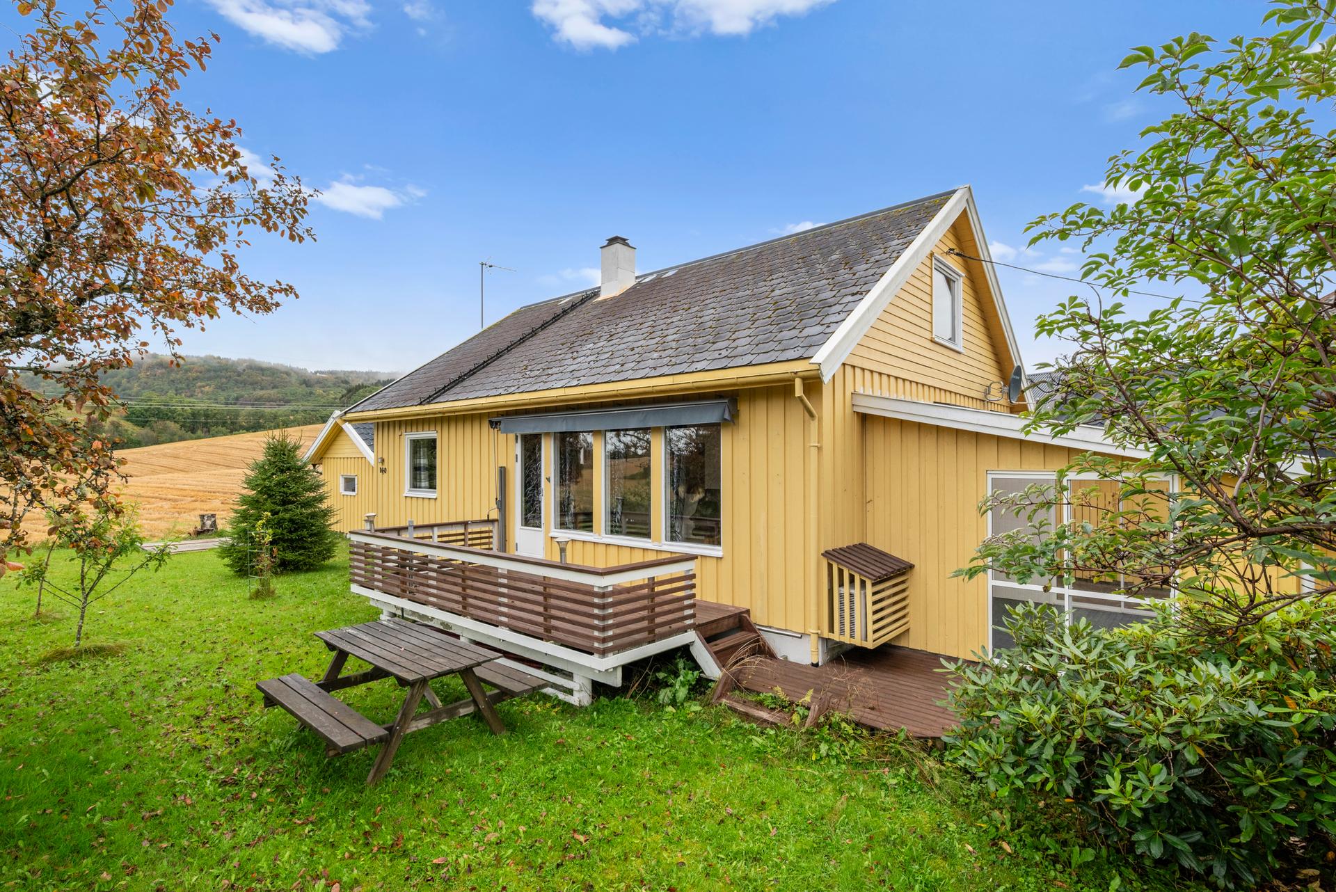 Eiendommen er pent opparbeidet med plen og prydebusker.. Bilde nummer 3 av 3