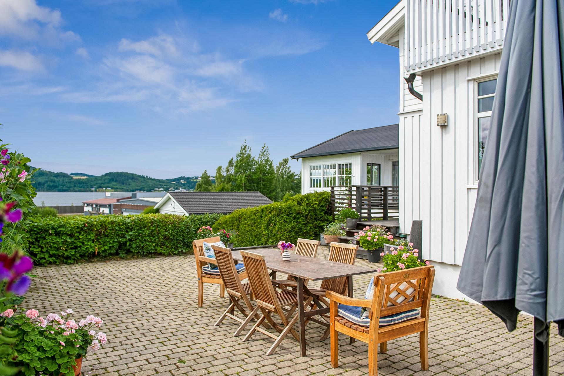 Idyllisk, steinlagt markterrasse med spiseplass og utsyn mot Mjøsa.. Bilde nummer 3 av 3
