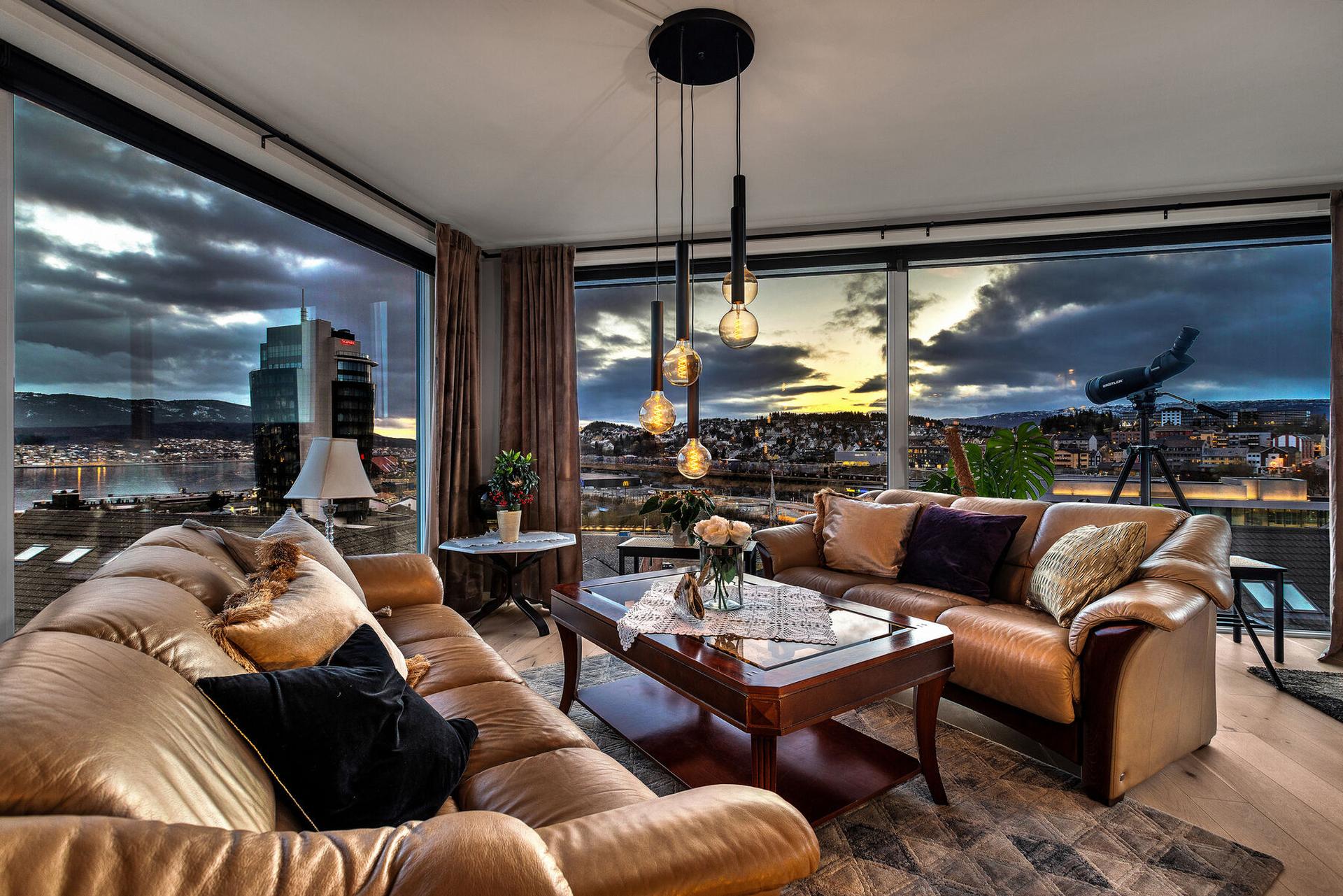 Hjørneplasseringen og de store vindusflatene gir en spektakulær utsikt over Narvik sentrum, havna og fjellene. Velkommen til en unik toppleilighet.  Foto: Punsvik foto. Bilde nummer 2 av 3