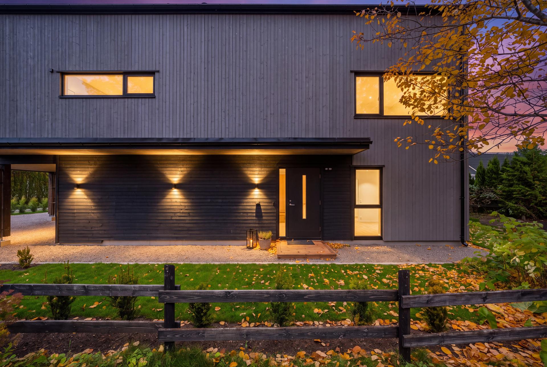 Nybygd enebolig over tre plan med integrert carport og moderne trepanel.. Bilde nummer 3 av 3