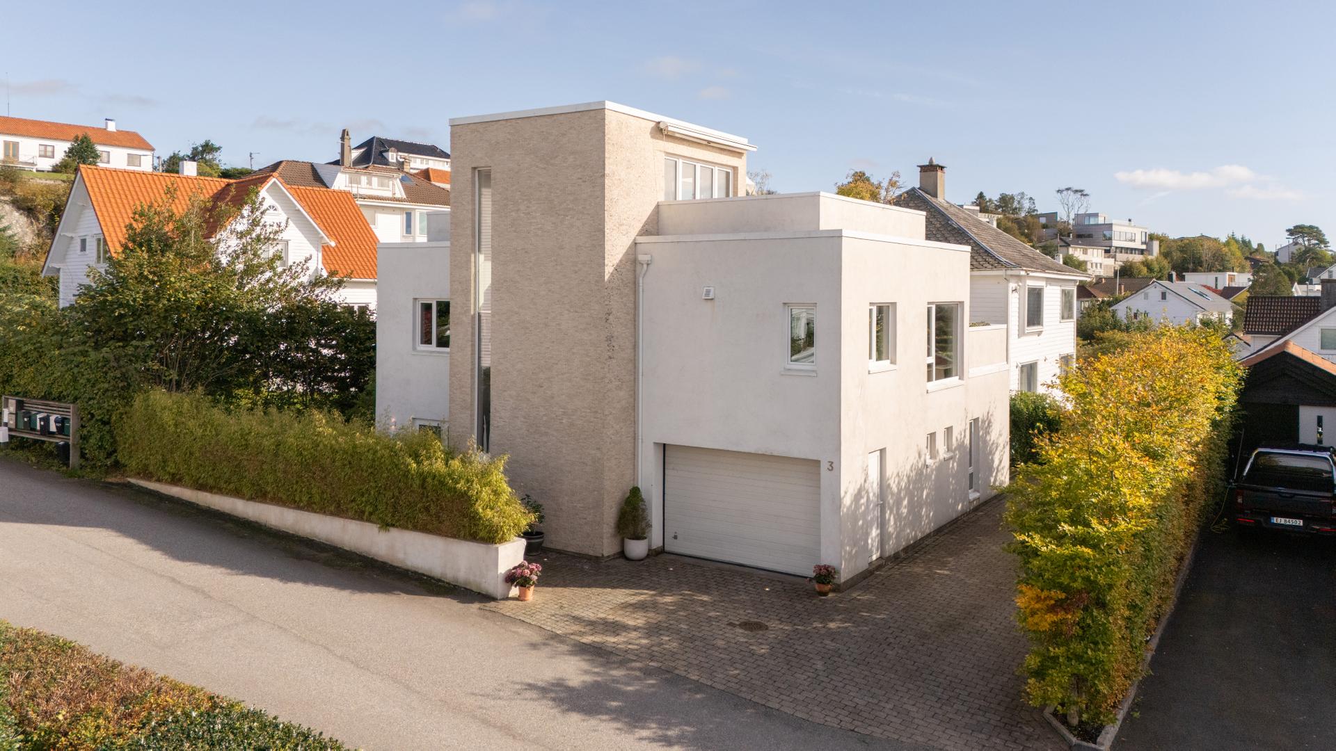 Moderne enebolig over fire plan med integrert garasje og solrike uteplasser på flere nivåer.. Bilde nummer 2 av 3