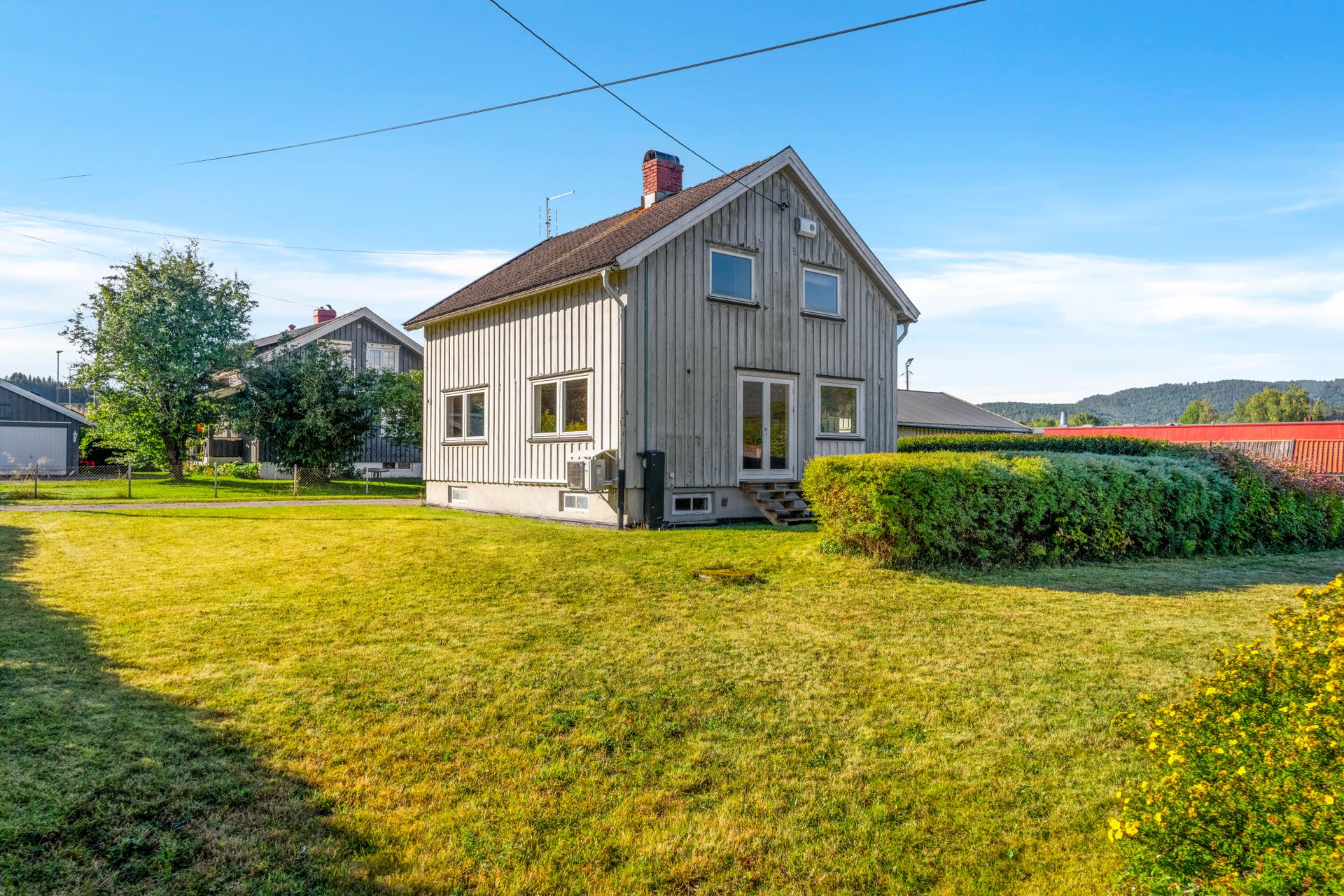 Frittliggende enebolig over tre plan med stor, flat hagetomt og frittstående dobbelgarasje.. Bilde nummer 2 av 3
