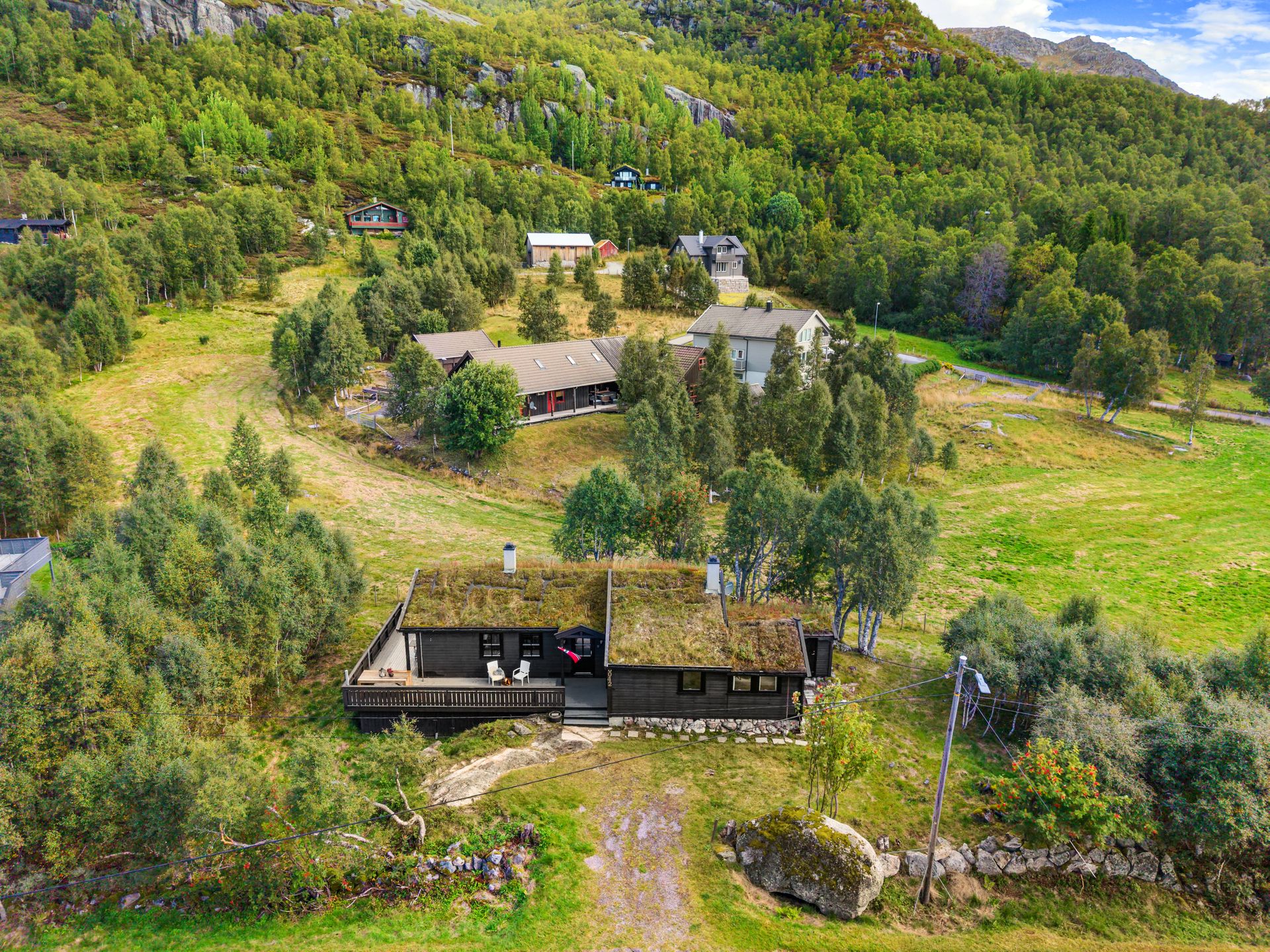 Hytten har tradisjonelt torvtak fra 2002 og ligger lunt til i terrenget.. Bilde nummer 3 av 3