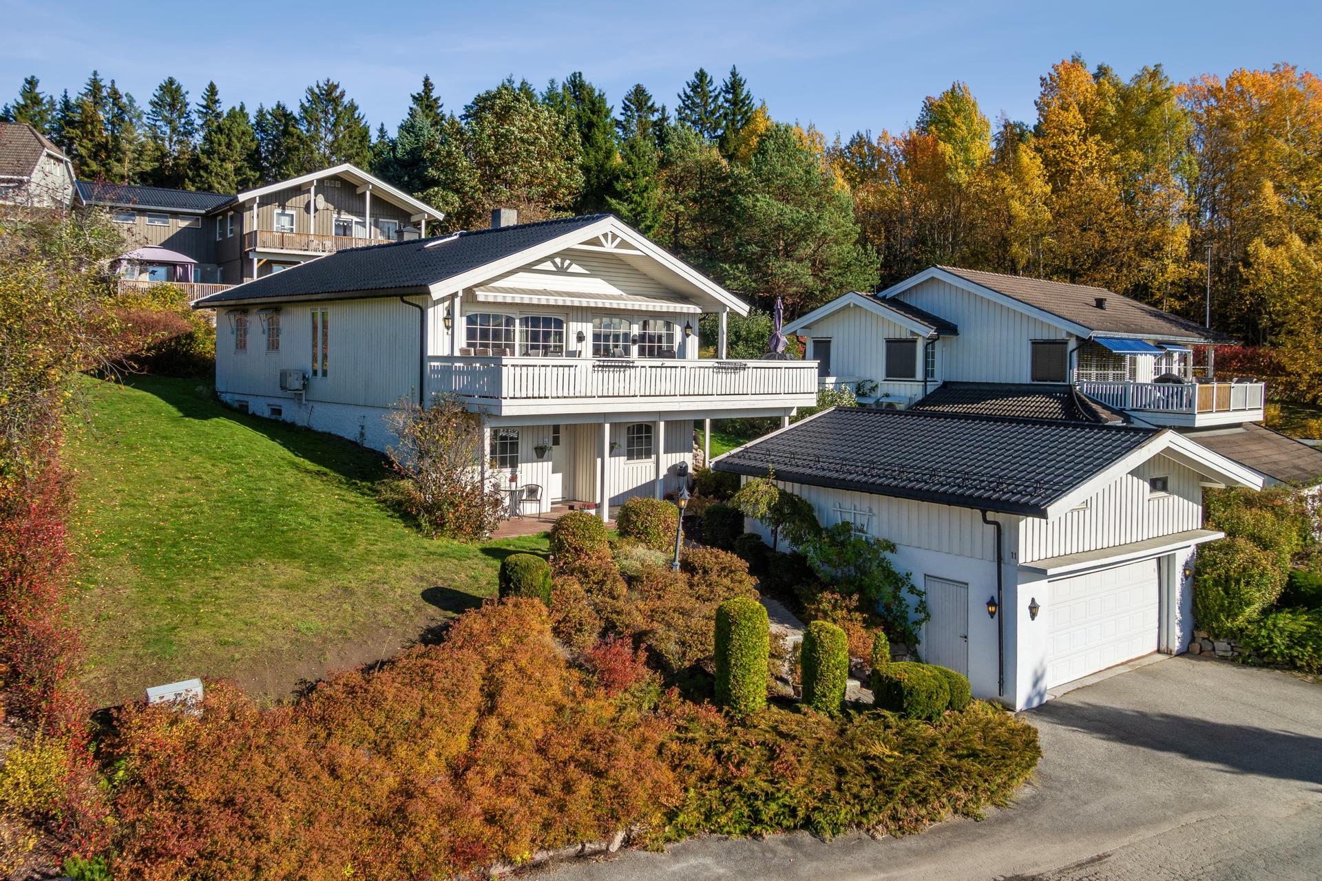 Asfaltert gårdsplass med parkeringsmuligheter foran garasjen og boligen.. Bilde nummer 2 av 3
