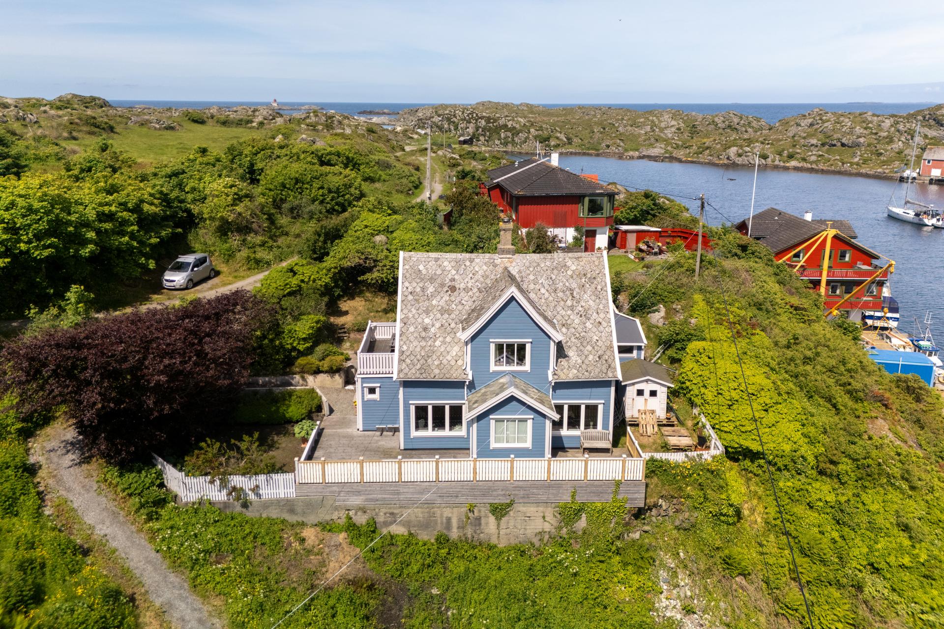 Eiendommen ligger vakkert til, omkranset av grønn natur og sjø.. Bilde nummer 2 av 3