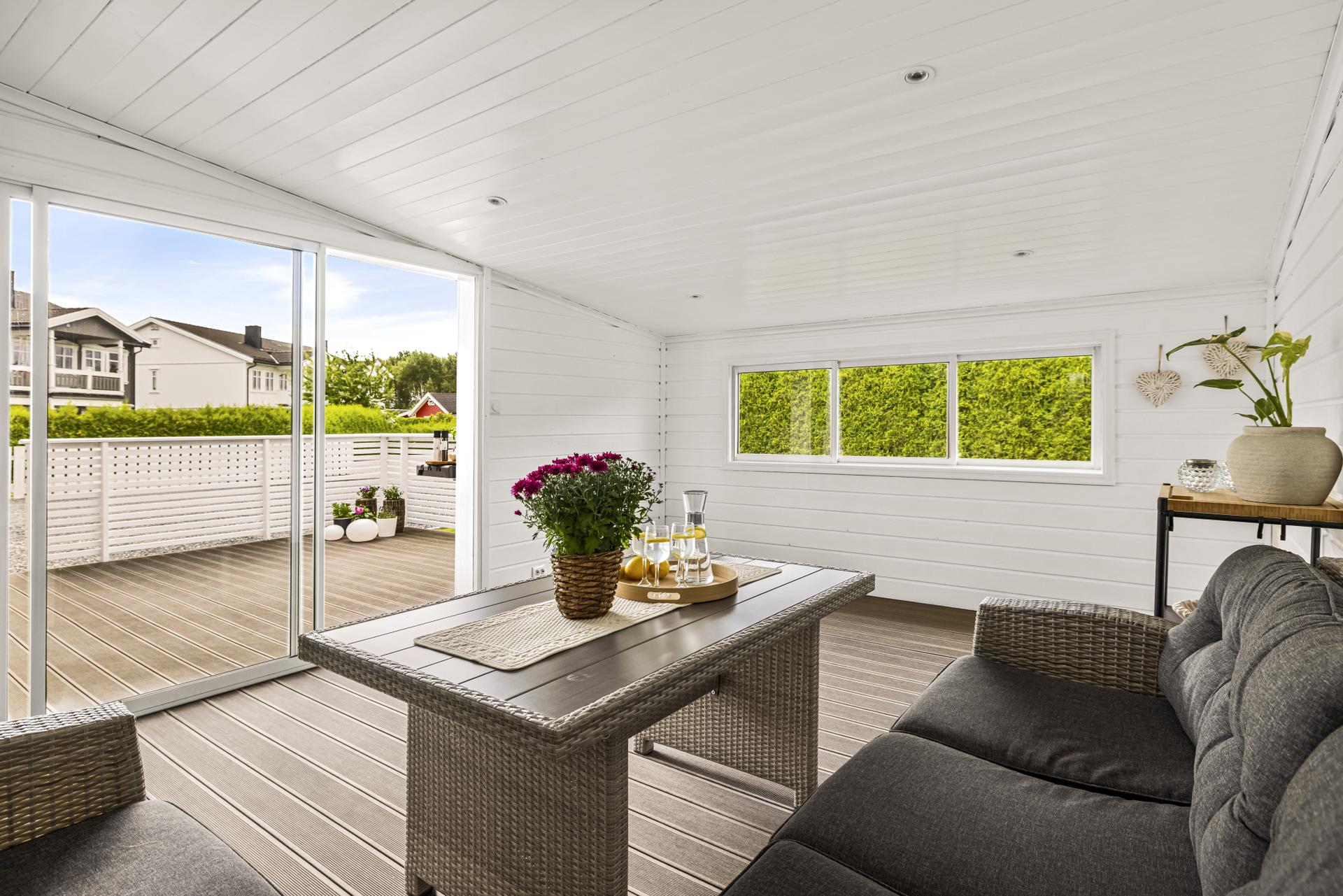 Den innglassede hagestuen har direkte utgang til en stor terrasse med vedlikeholdsvennlig komposittgulv.. Bilde nummer 3 av 3
