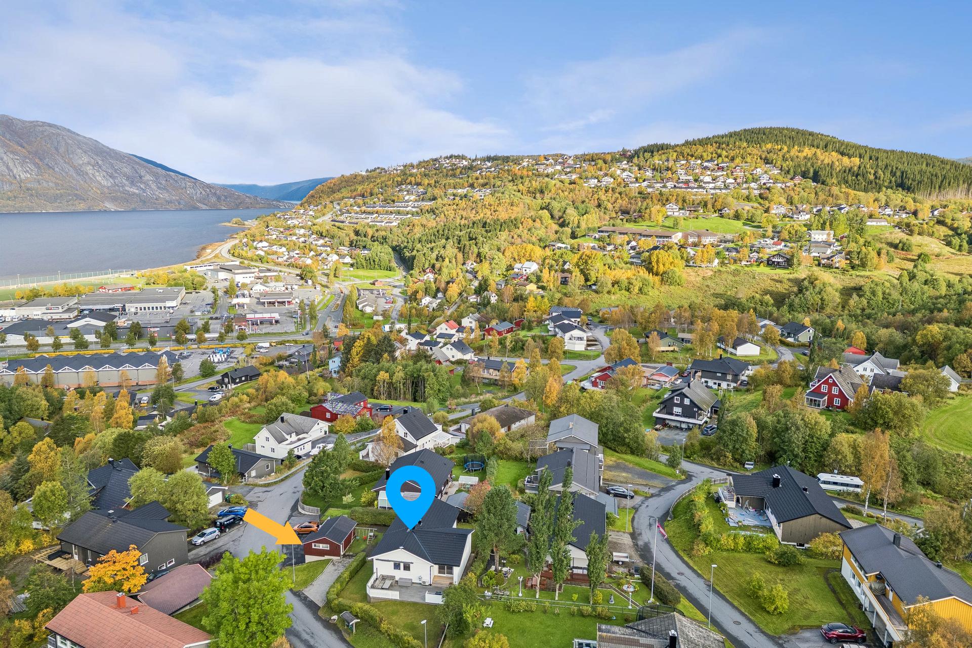 Oversikt over nærområdet med kort vei til butikker og servicetilbud på Halsøy. Blå markør viser hus, mens oransje pil viser garasjene.. Bilde nummer 2 av 3