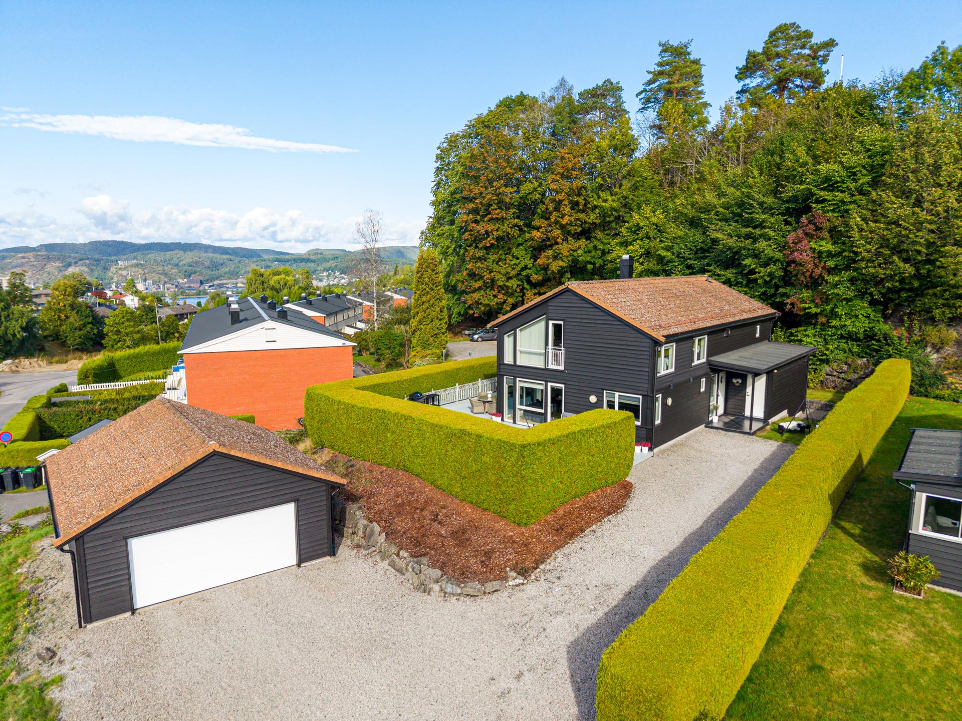 Enebolig over to plan på Flåtten med frittstående dobbelgarasje og usjenerte uteplasser. Tett og velstelt tujahekk rammer inn eiendommen og skjermer godt mot innsyn.. Bilde nummer 3 av 3