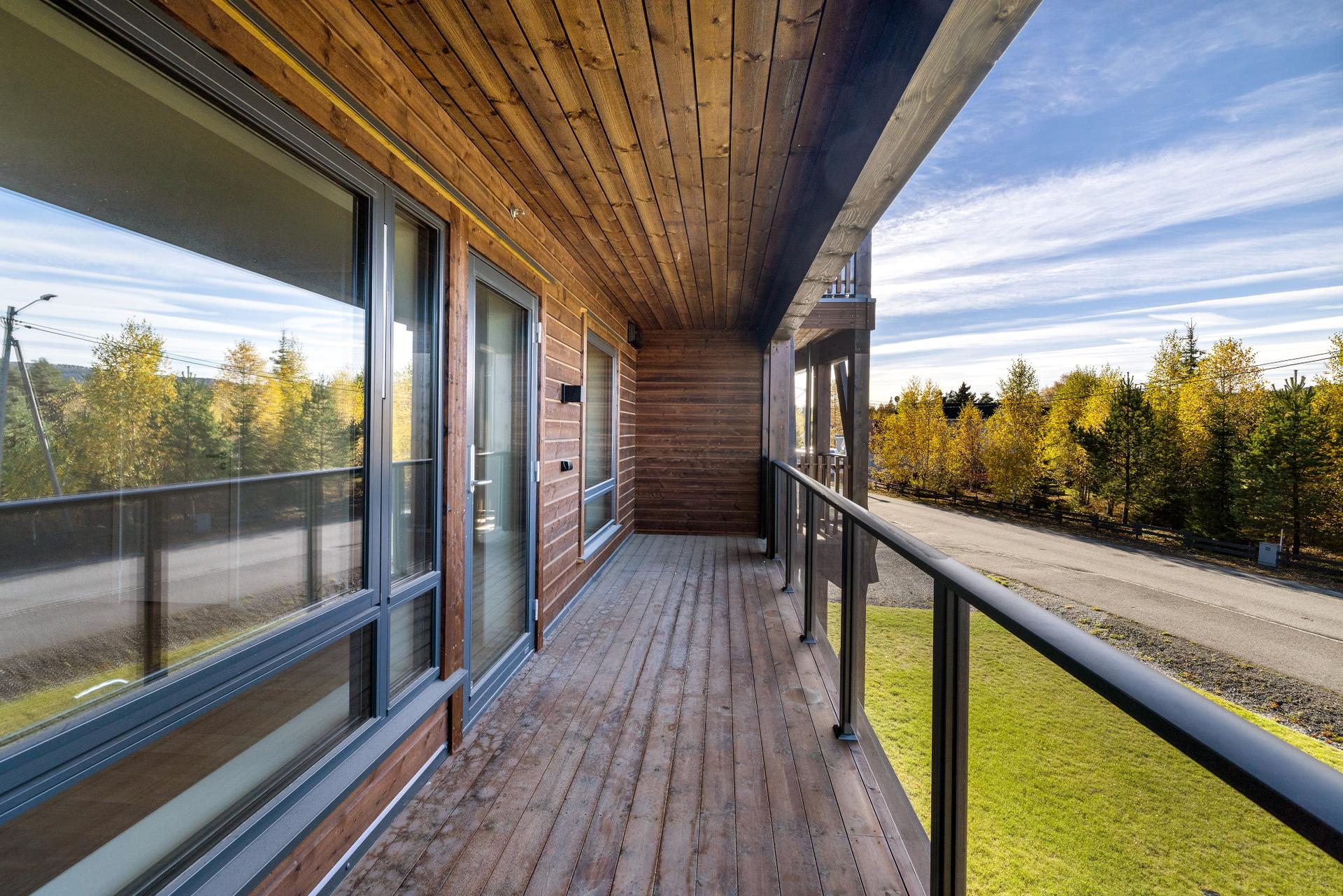 Fra stuen er det direkte utgang til en overbygget balkong med impregnerte terrassebord og glassrekkverk.. Bilde nummer 3 av 3
