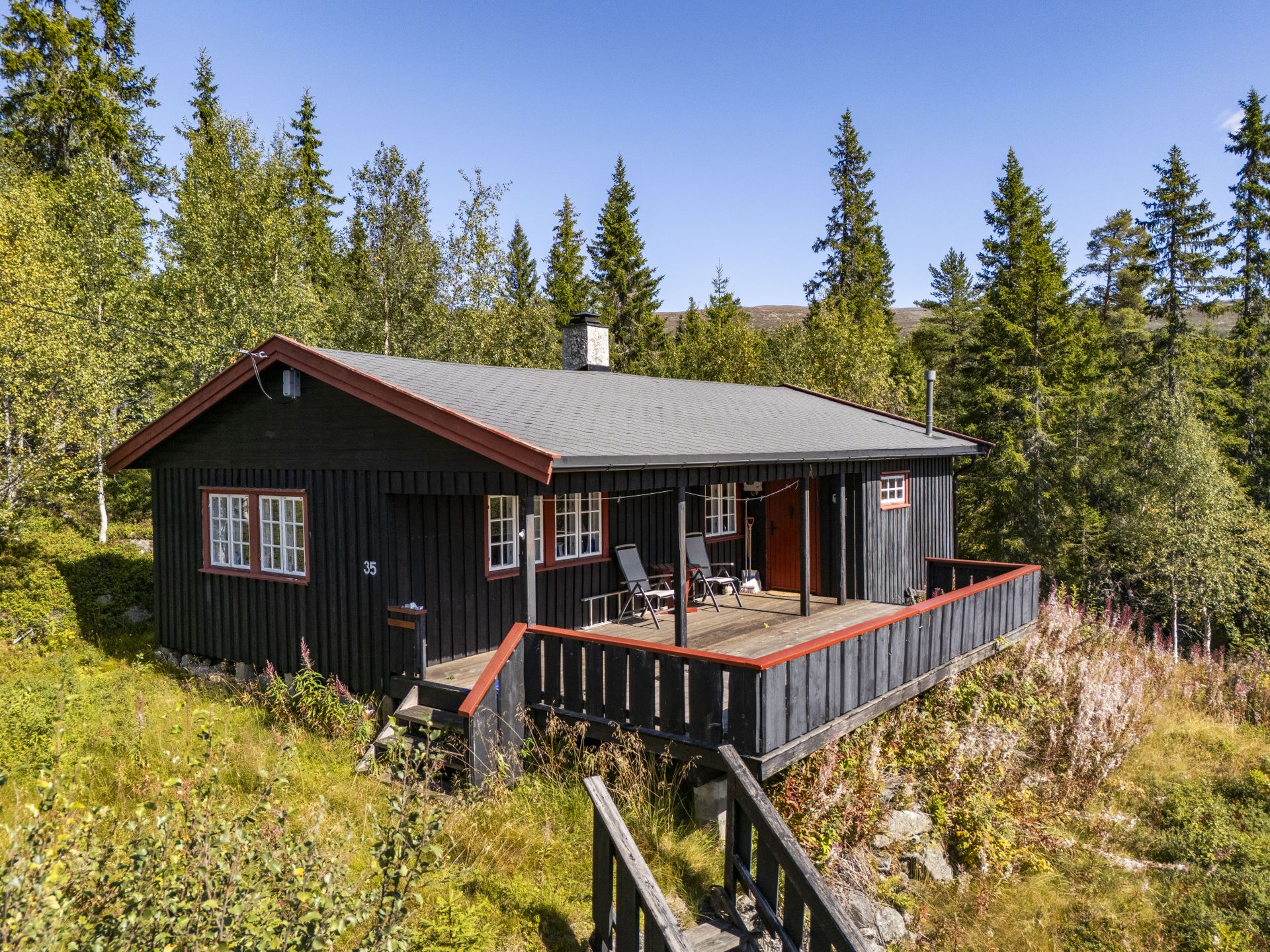 Hytta ligger fint til i etablert område med helårs bilvei frem. Bilde nummer 2 av 3