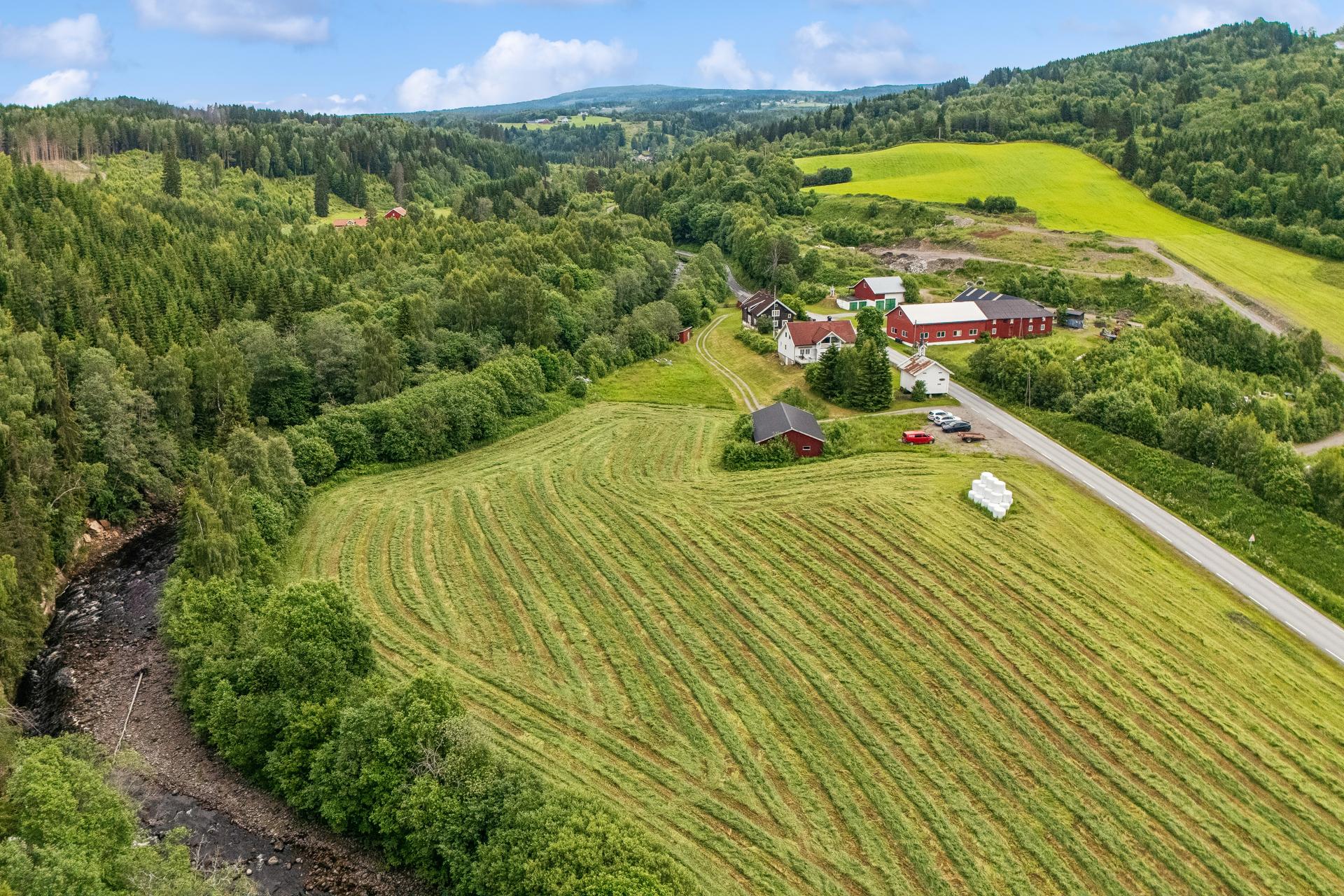 Landbrukseiendom på ca. 17,1 mål med to våningshus, fem driftsbygninger og ørret elven Brumunda som renner langs tomten.. Bilde nummer 2 av 3