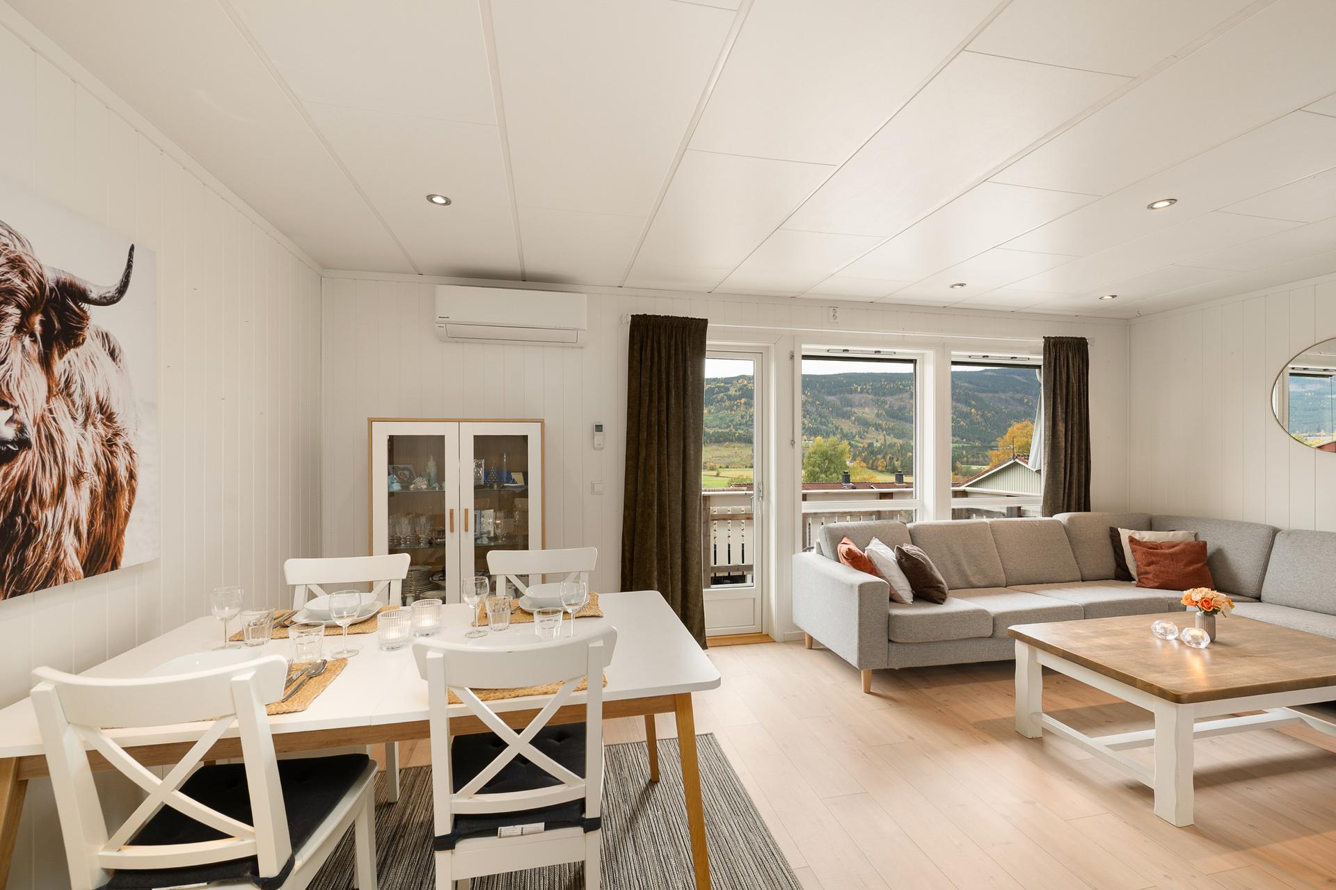 Stuen har god plass til både sofagruppe og spisebord, med utgang til verandaen.. Bilde nummer 3 av 3