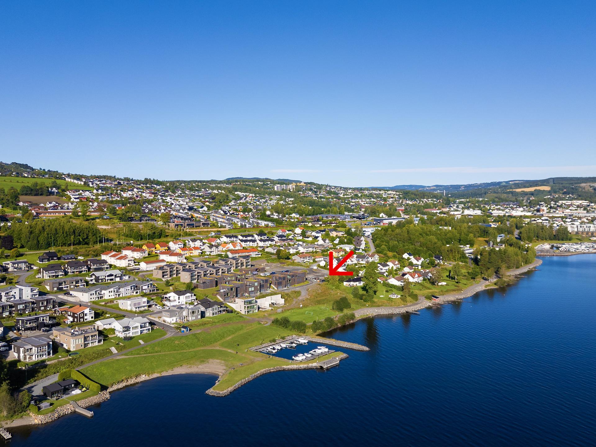 Bondelia Park - et rolig og barnevennlig boligområde med fantastisk beliggenhet ved Mjøsa. De tre flotte atriumshusene som nå er i salg vil få en flott beliggenhet på høyden bak den hvite villaen på foto. . Bilde nummer 3 av 3