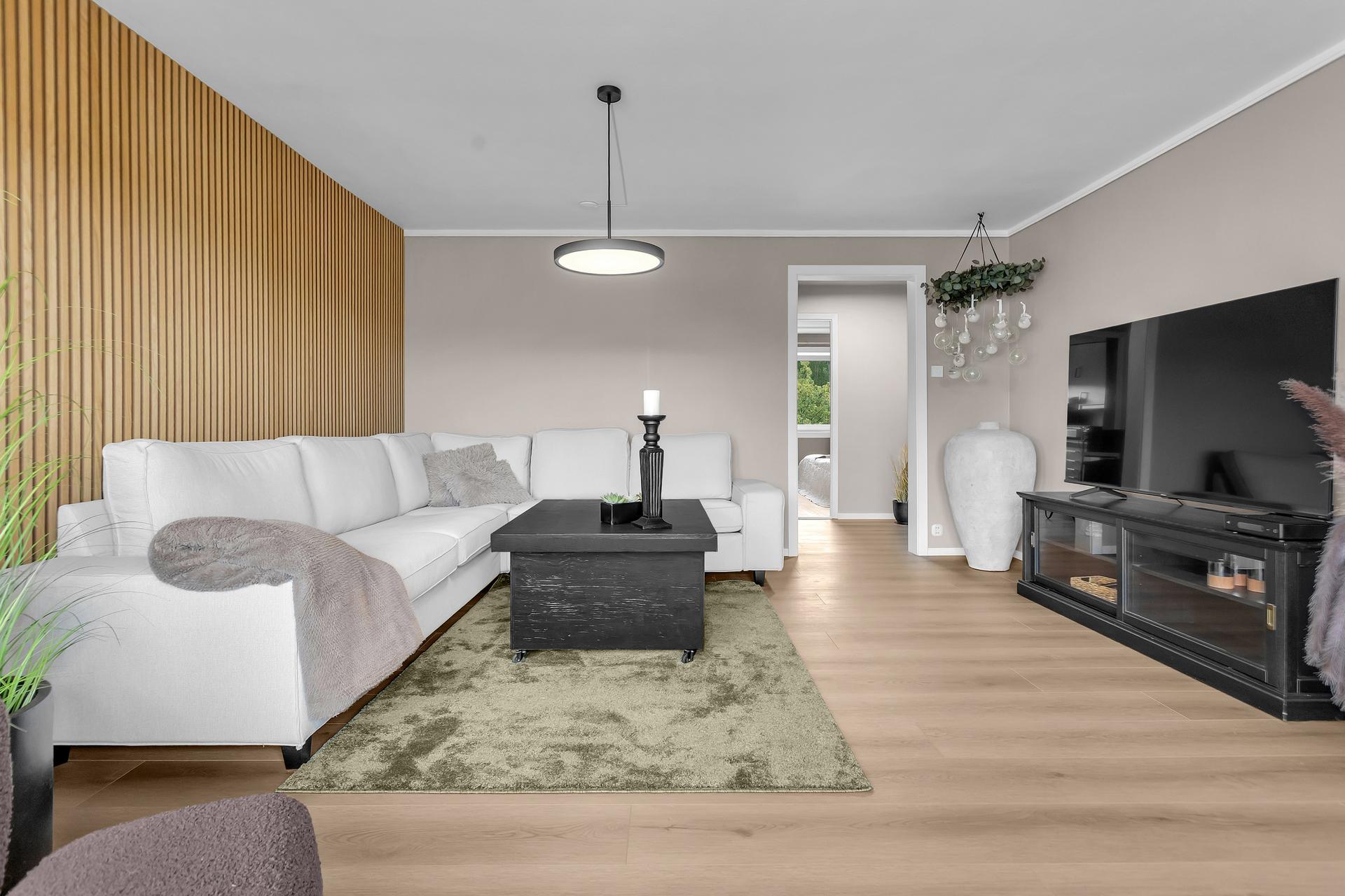 Stuen er leilighetens hjerte – lys, romslig og innredet med moderne kvaliteter som skaper en lun atmosfære. . Bilde nummer 3 av 3