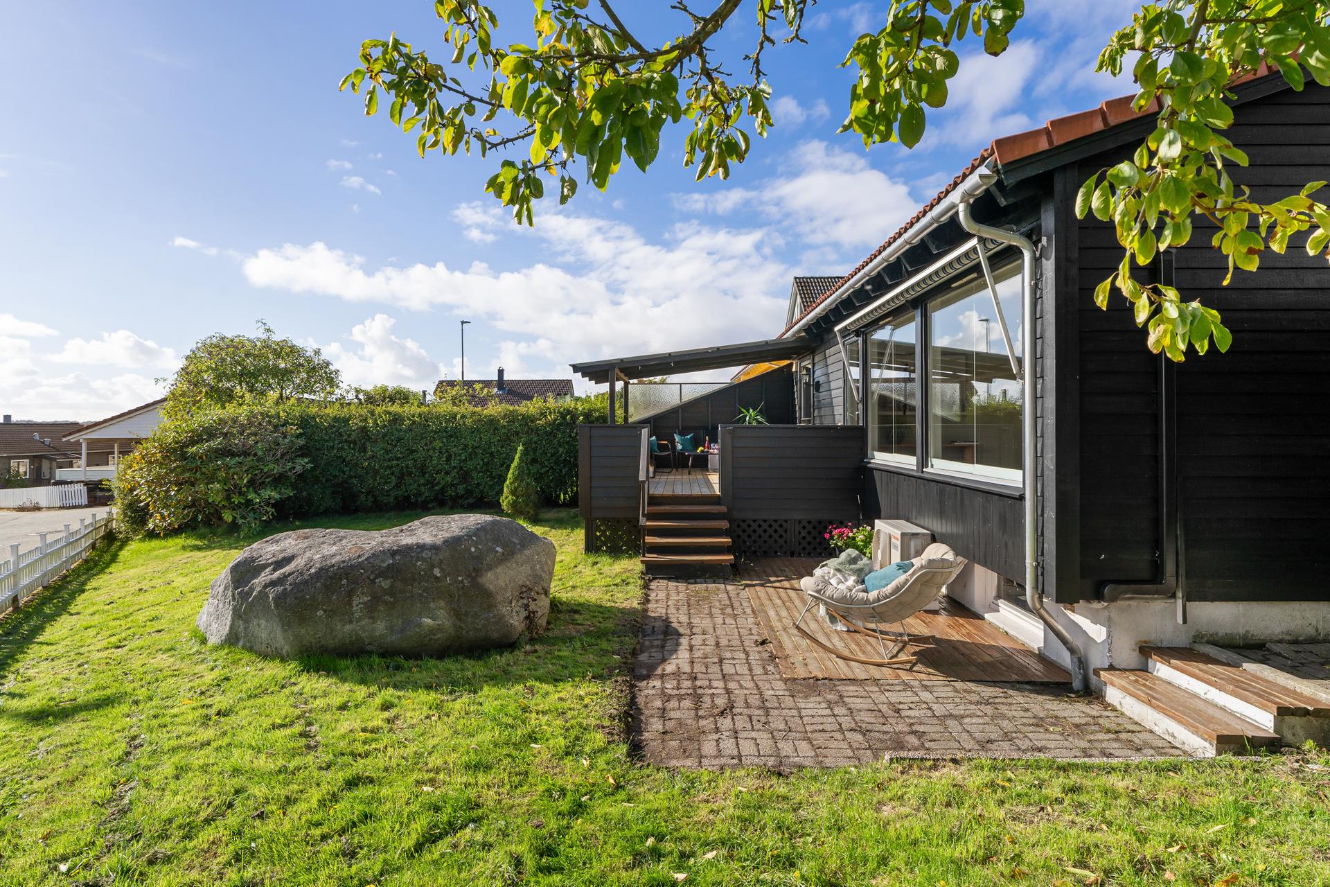 Skjermet hage og sørvendt terrasse med trappeadkomst ned til plenen.. Bilde nummer 3 av 3