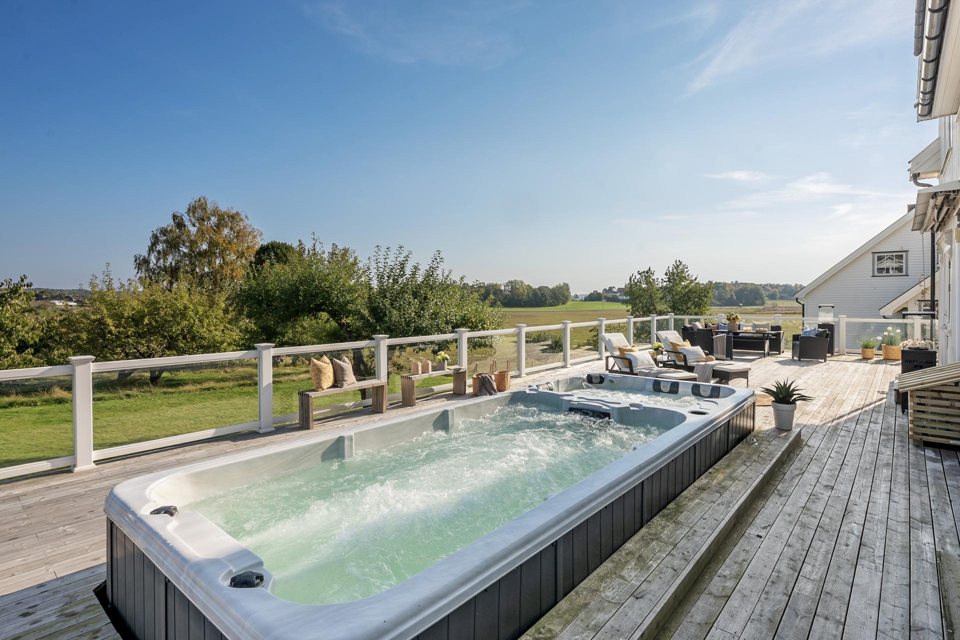 Den store terrassen er oppgradert med et eksklusivt, nedfelt motstrømsbasseng med jacuzzi – perfekt for både trening, rekreasjon og hyggelige stunder med familie og venner. Bilde nummer 3 av 3