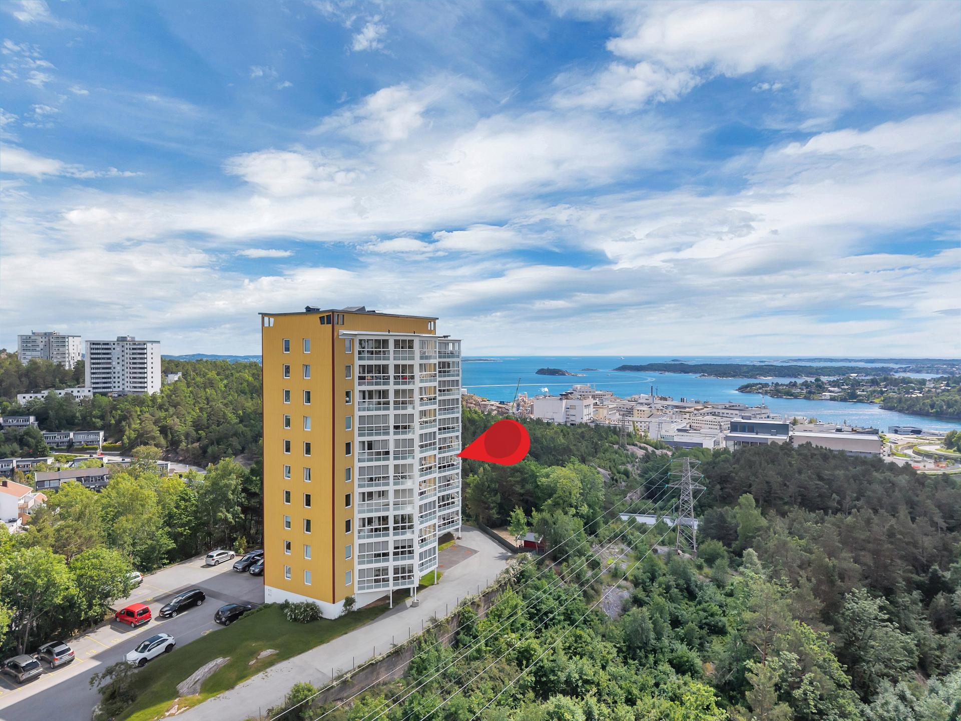 Leiligheten har en høytliggende og fri plassering på Tinnheia, i et veletablert og rolig boligområde. Fra eiendommen er det vidstrakt utsikt over Kristiansand, skjærgården og innseilingen mot byen.. Bilde nummer 2 av 3