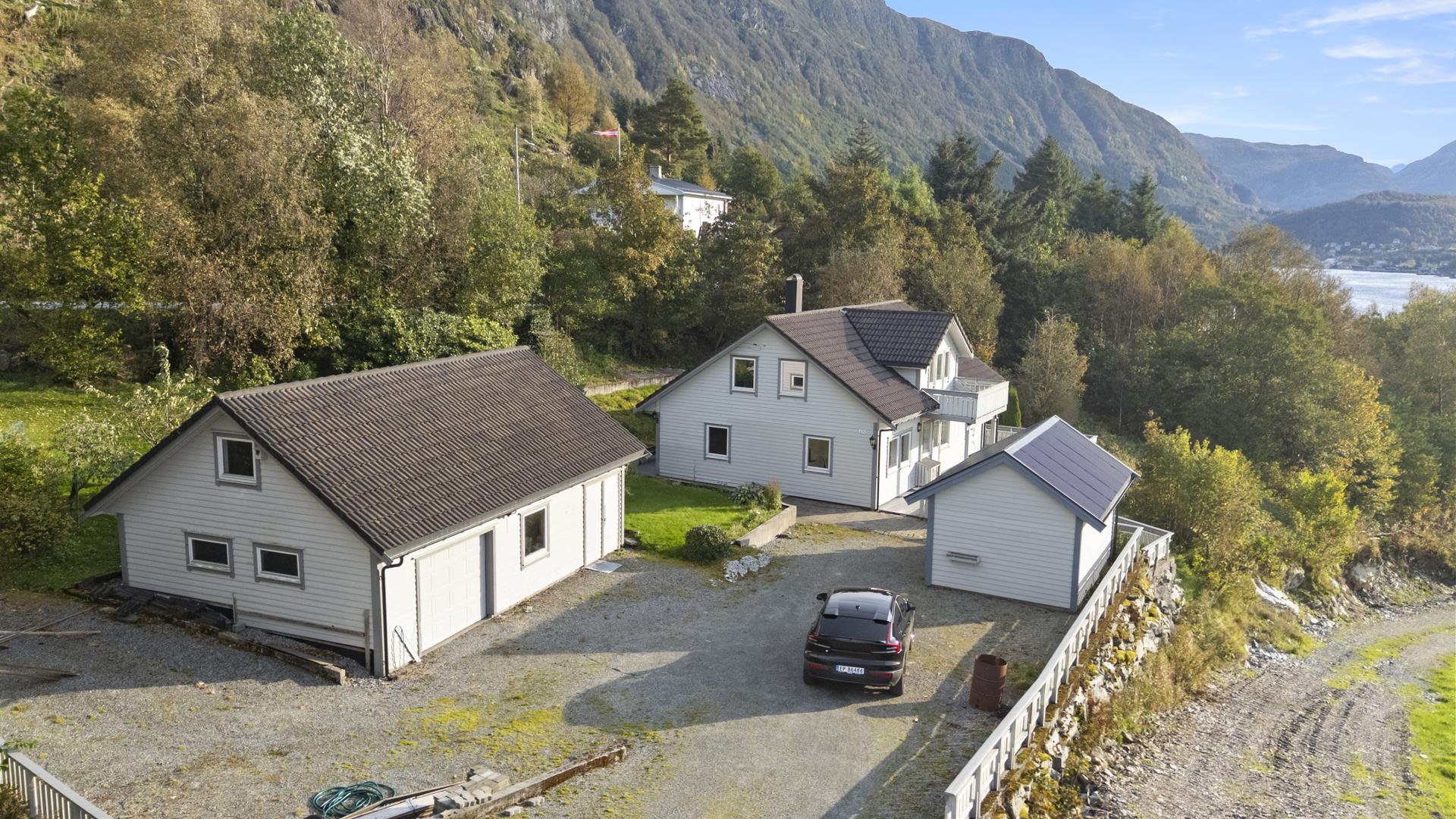 Eigedomen er utbygd med einebustad, garasje og uthus, samt eit romslig grusa tun med god plass til parkering og enkel tilkomst mellom bygningane.. Bilde nummer 3 av 3