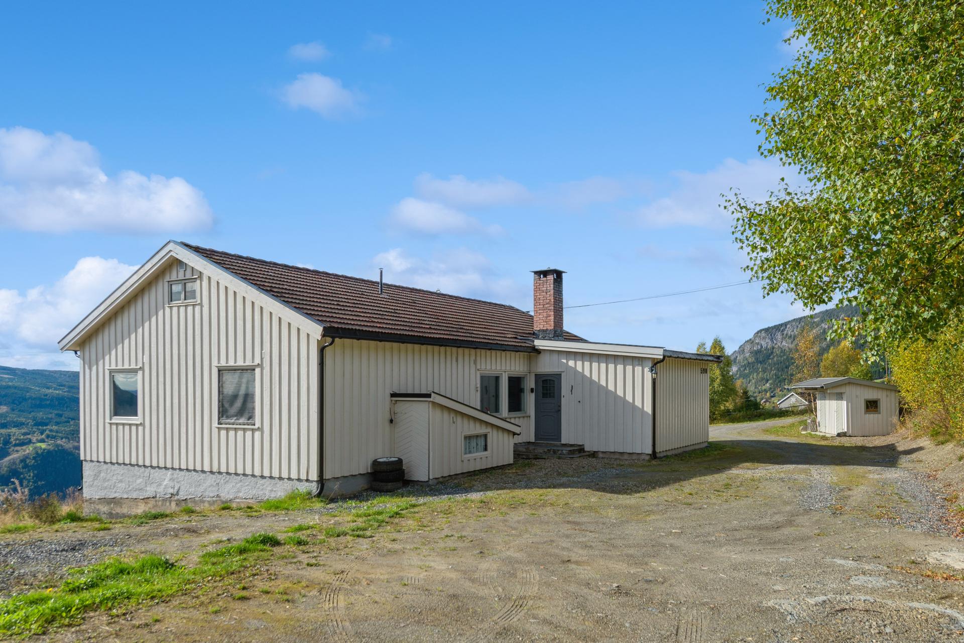 Bolighuset har stående trekledning og tak tekket med takstein. Bilde nummer 3 av 3