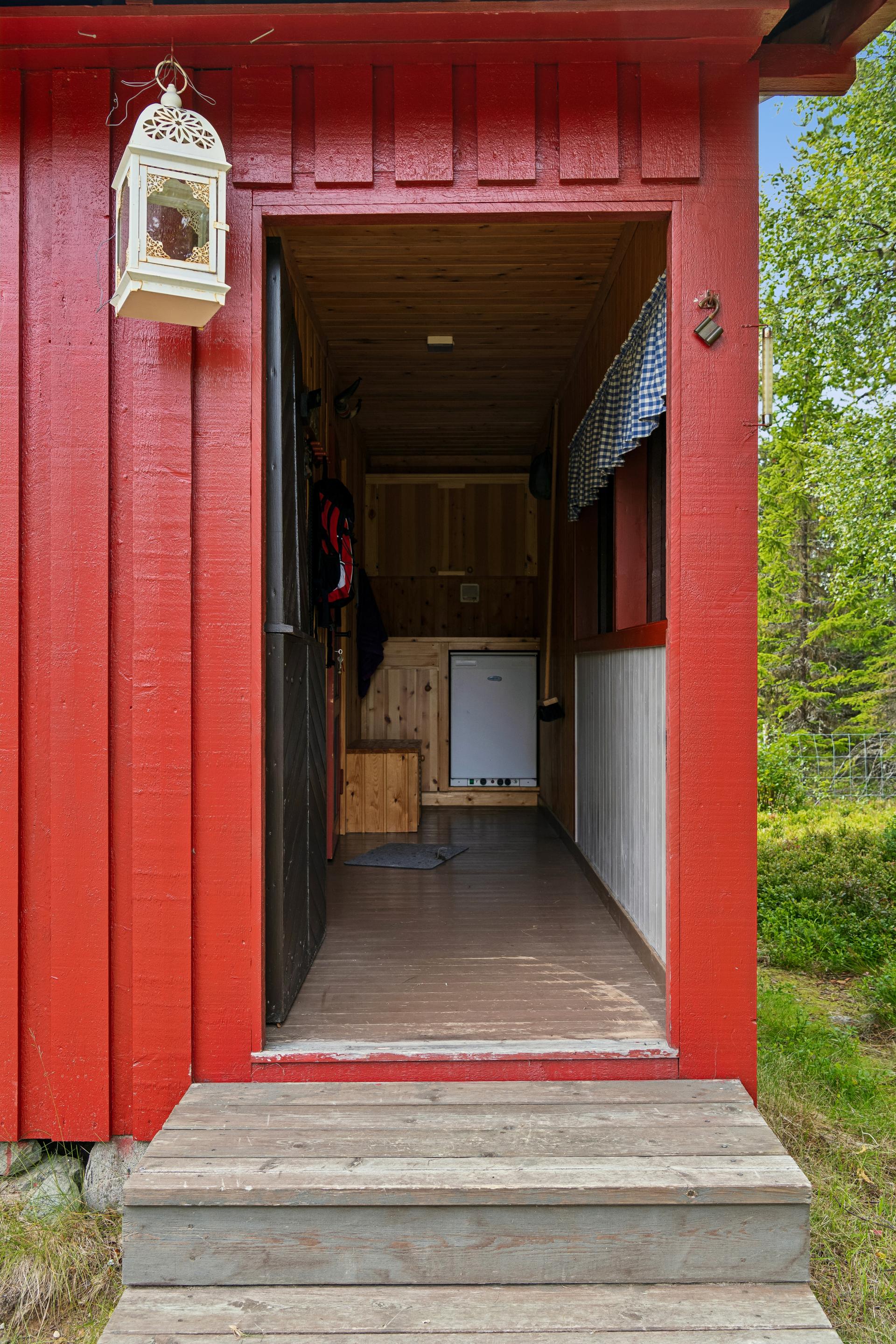 Inngangspartiet har en solid, malt heltre ytterdør utformet som en stalldør.. Bilde nummer 2 av 3