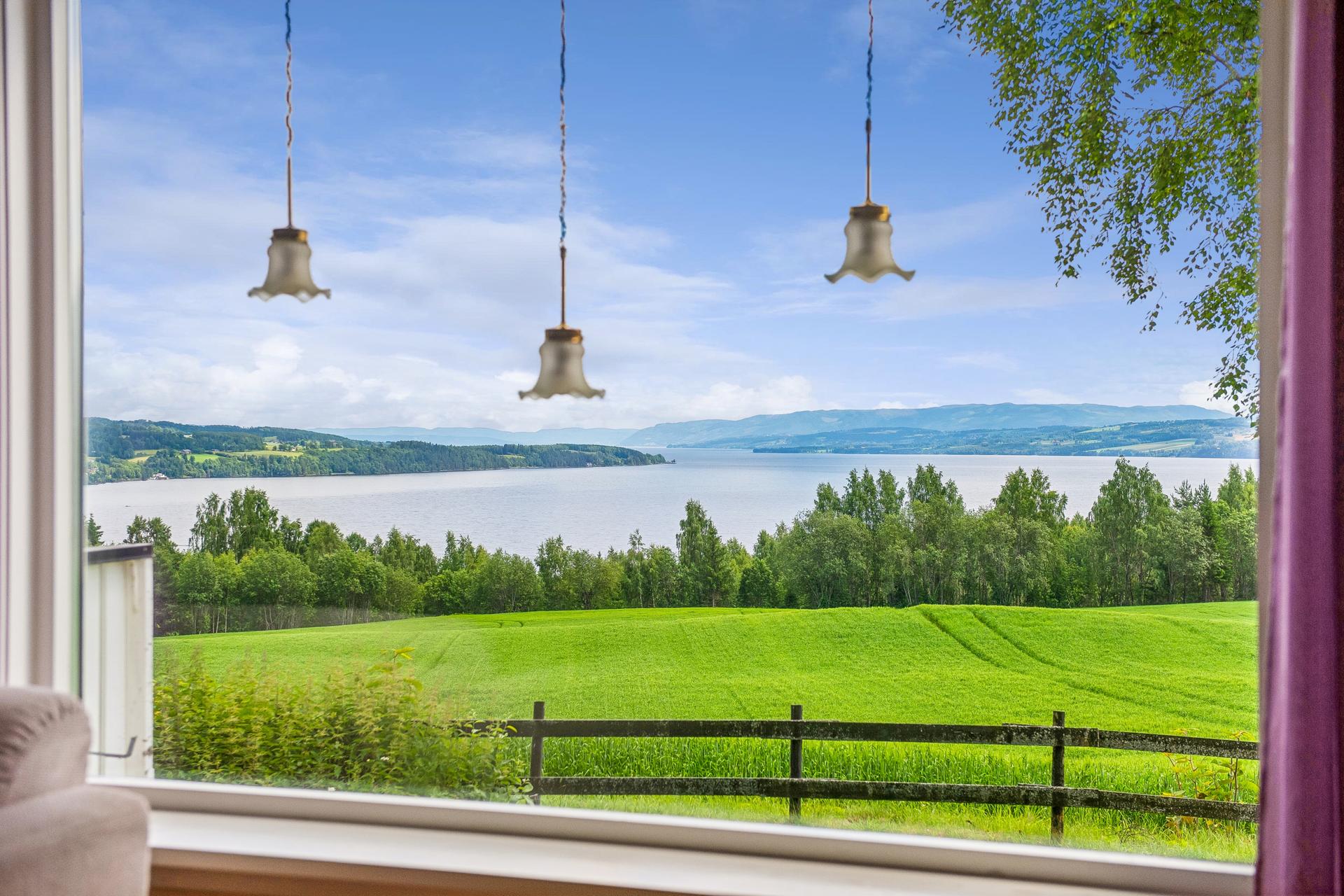 Fra stuen og fra terrassen er det vidstrakt utsikt over kulturlandskapet og Mjøsa. Helt magisk!. Bilde nummer 3 av 3