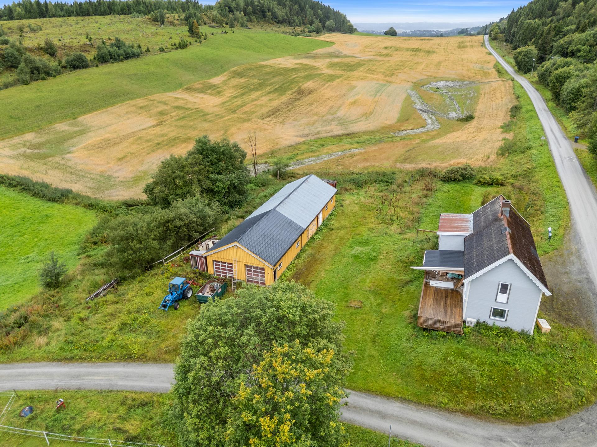 SMåbruk med stort uthus.  Det er garasje og stall i uthuset. . Bilde nummer 2 av 3