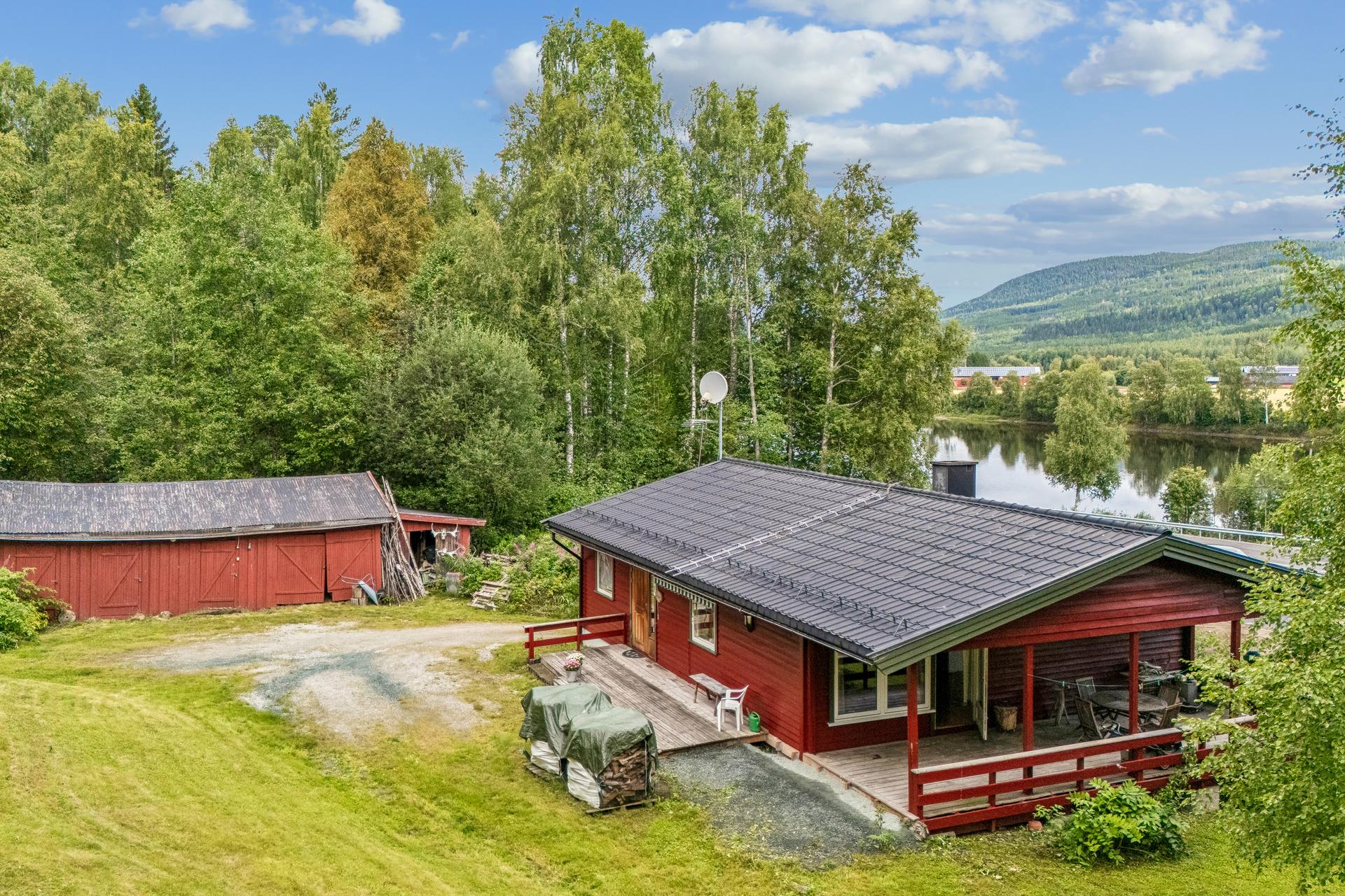 Boligen fra 1966 har stor eiertomt, uthus og en rolig beliggenhet i naturskjønne omgivelser.. Bilde nummer 2 av 3