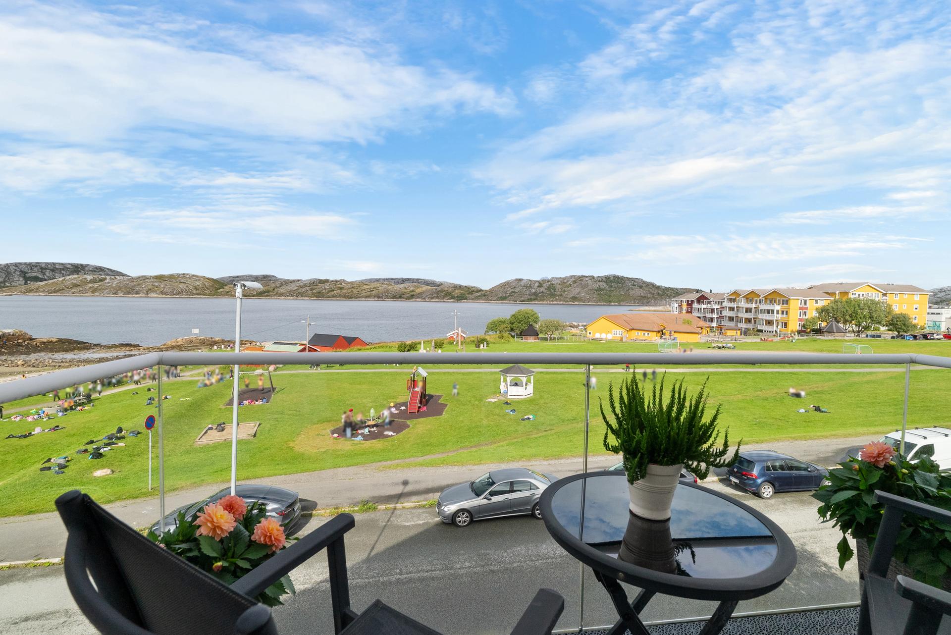 Fra balkongen har du fri utsikt over grøntområder og sjøen.. Bilde nummer 3 av 3