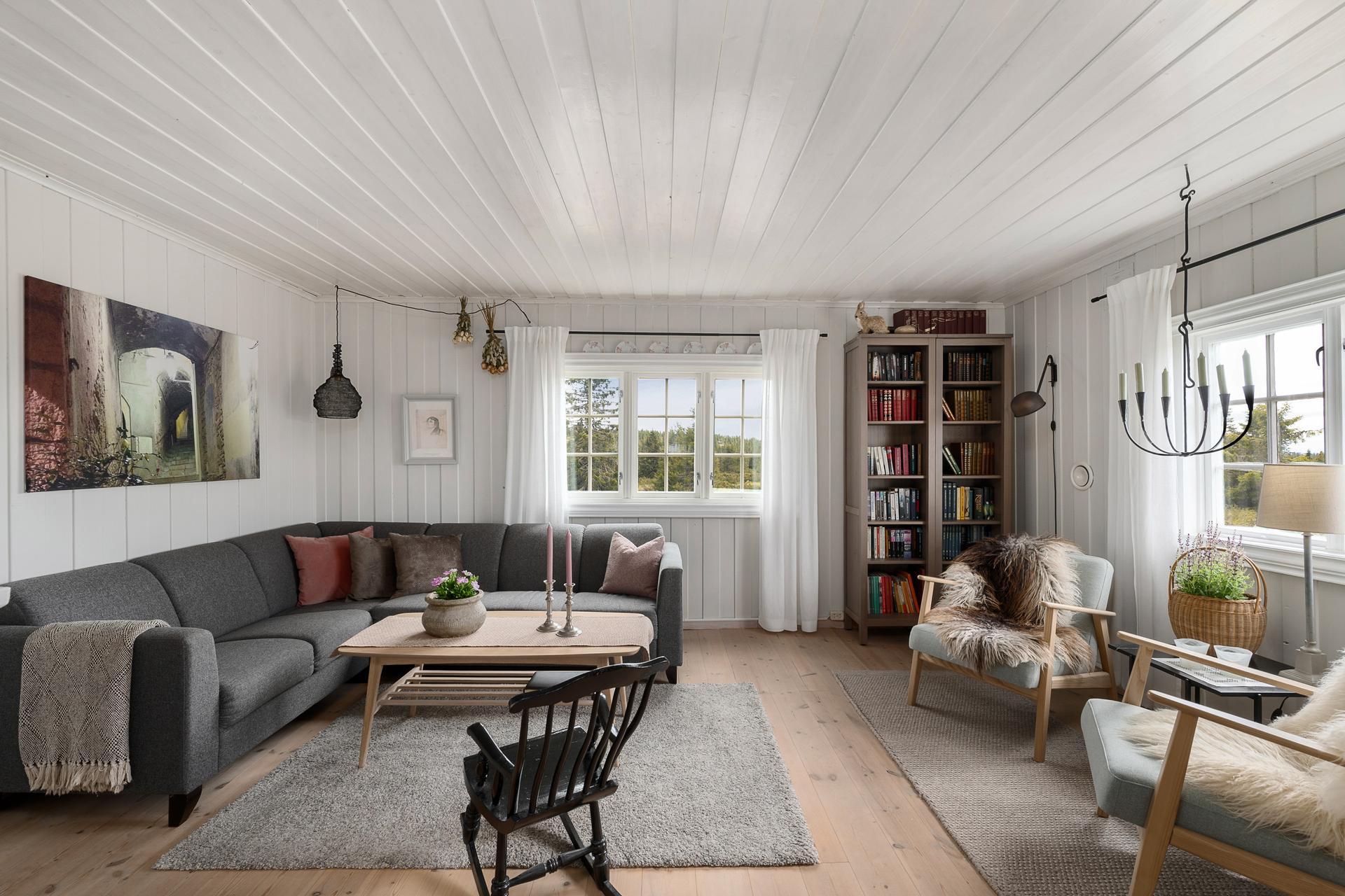 Hytta har en sosial og åpen planløsning med god plass til en romslig sofagruppe.. Bilde nummer 2 av 3